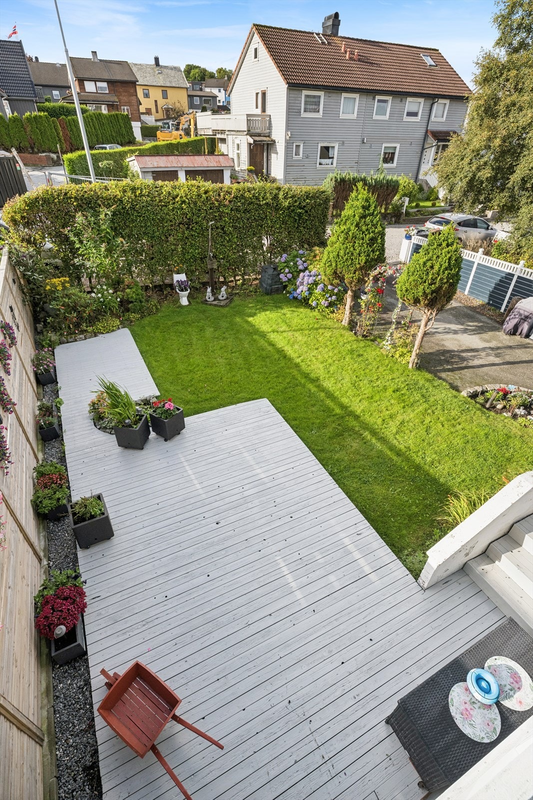 Oversiktlig hage med plen, prydbusker og tilknyttet markterrasse. Galleribilde