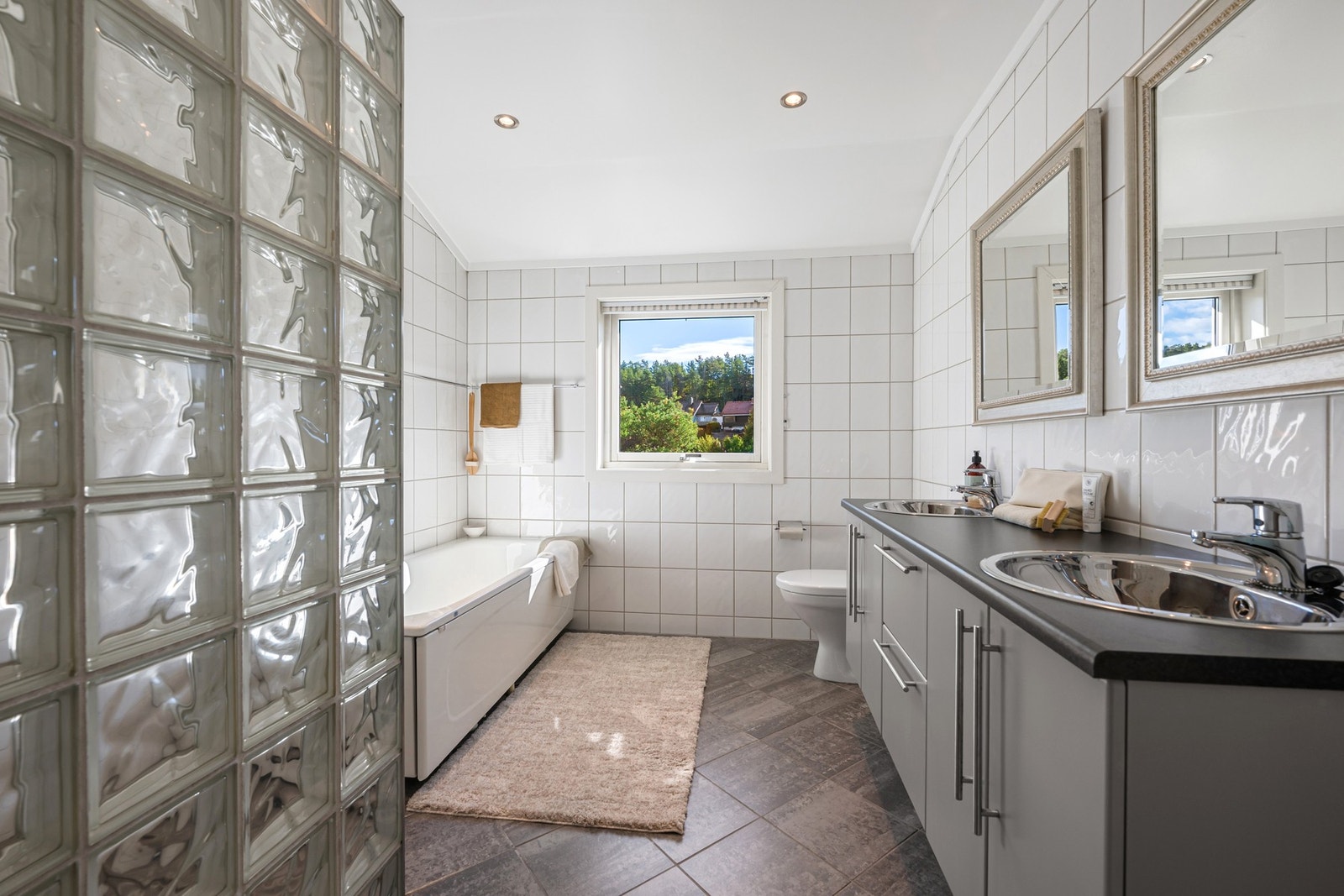 Badet i 2. etasje er flislagt med 30 x 30 cm gulvfliser og hvite 20 x 25 cm fliser på veggene. Galleribilde