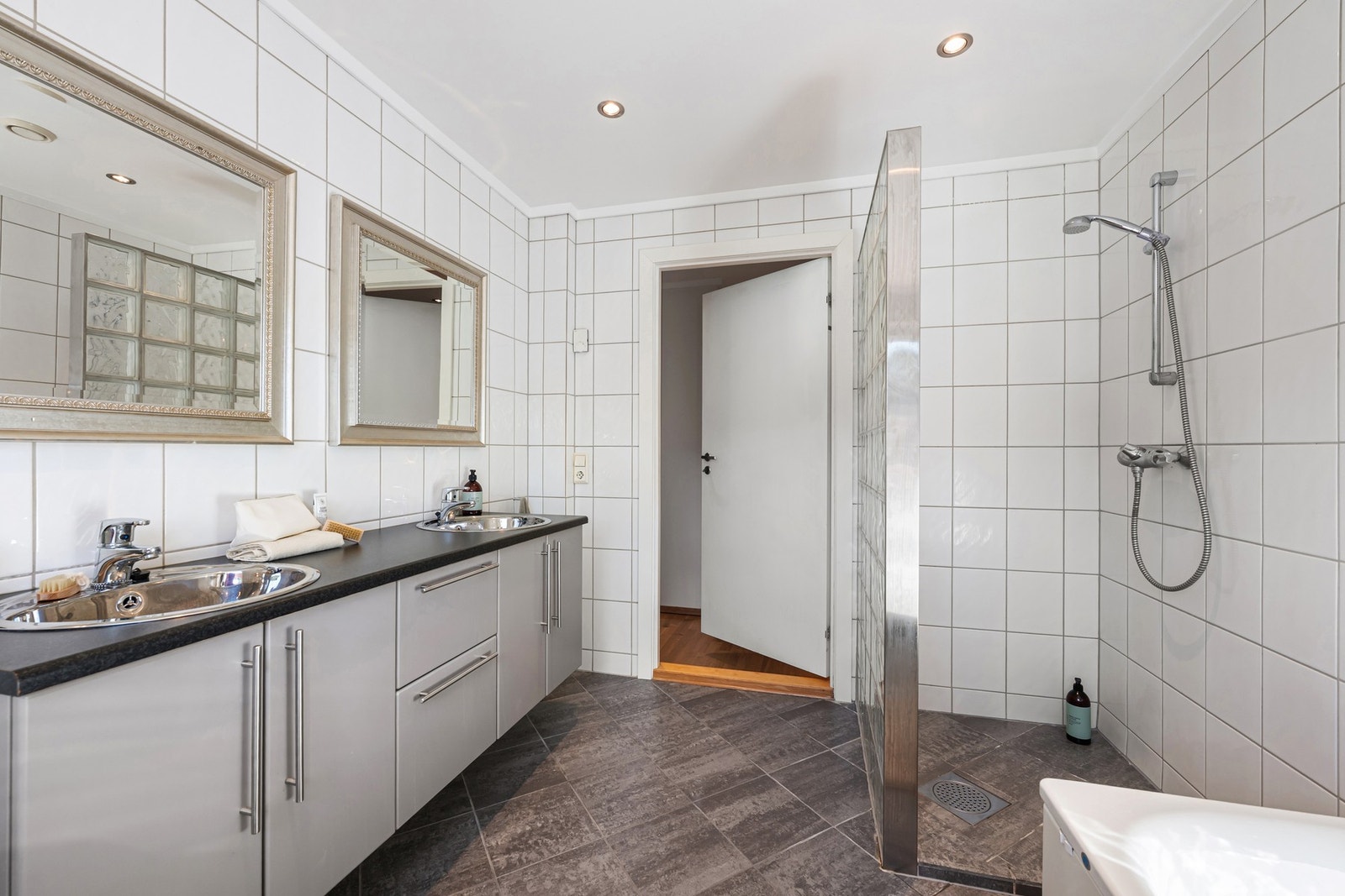 Dusjsonen er avskjermet med glassvegg, mens downlights i himlingen og gulvvarme bidrar til komfort i hverdagen. Badet har mekanisk avtrekk. Galleribilde