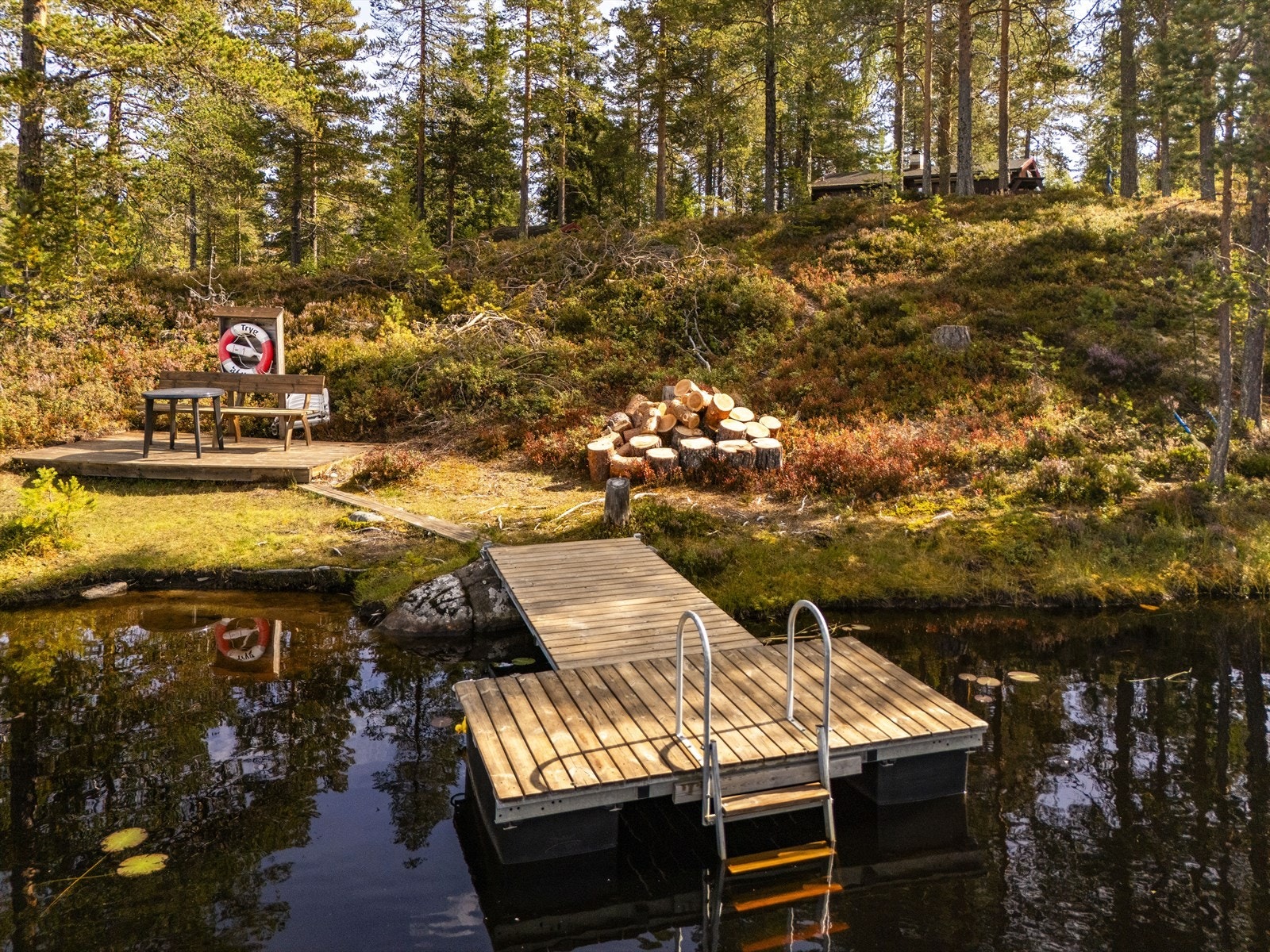 Nedenfor eiendommen er det en badebrygge og uteplass som er felles for flere hyttenaboer. Galleribilde