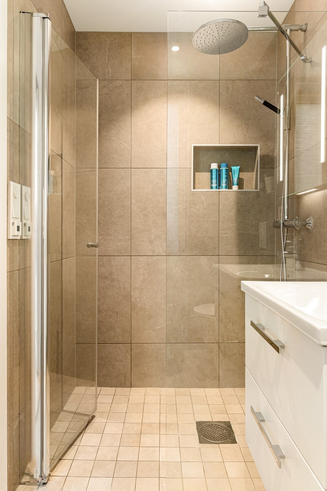 Badet er helfliset og har dusjløsning med glassvegg. Galleribilde