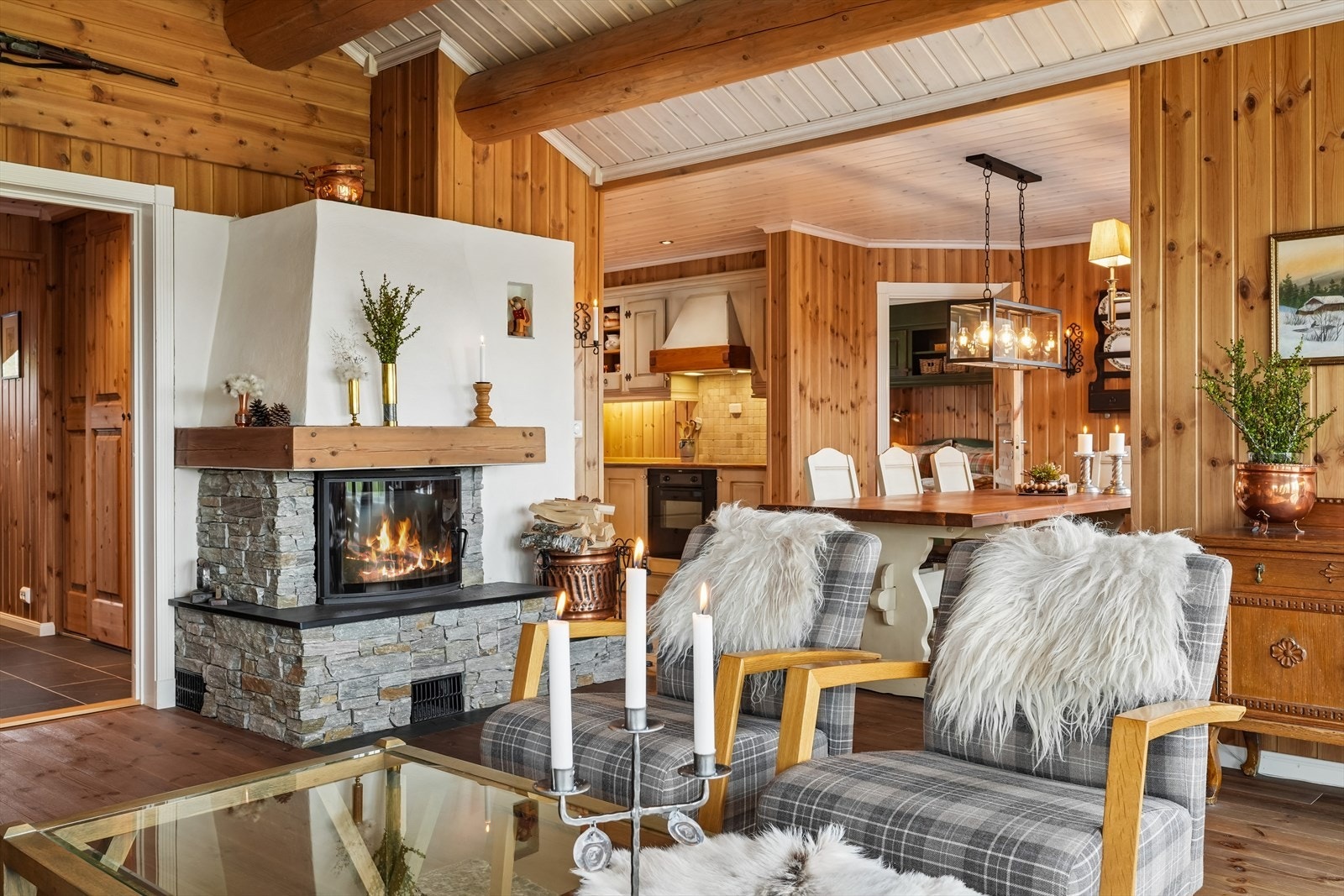 Den plassmurte peisen med innsats, forblendet med naturstein, fungerer som et naturlig samlingspunkt og skaper både varme og stemning på kjølige dager og kvelder. Galleribilde
