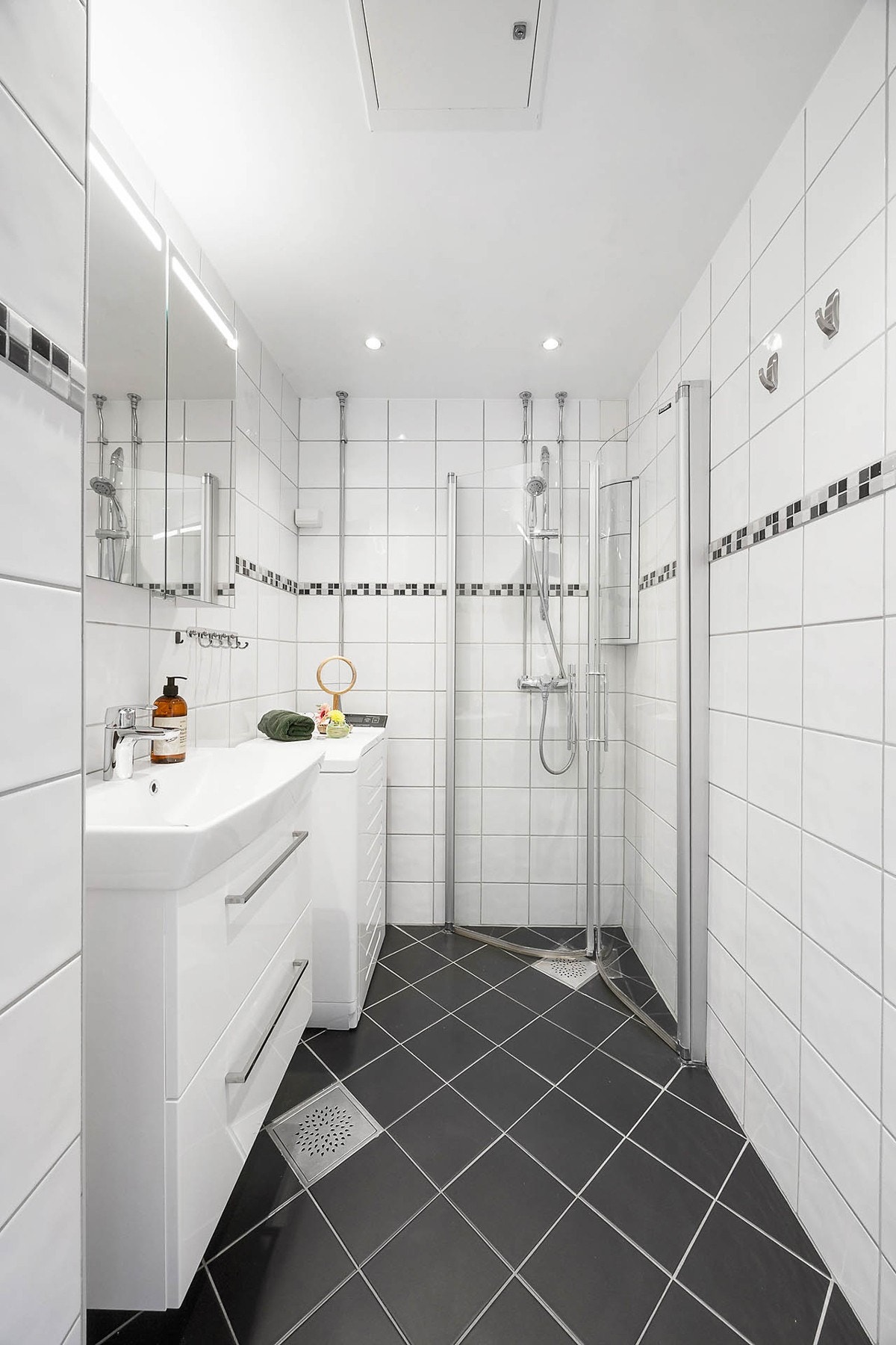 Lyst og delikat baderom med varmekabler, downlights og opplegg for vaskemaskin. Badet ble pusset opp i regi av brl i 2009. Galleribilde