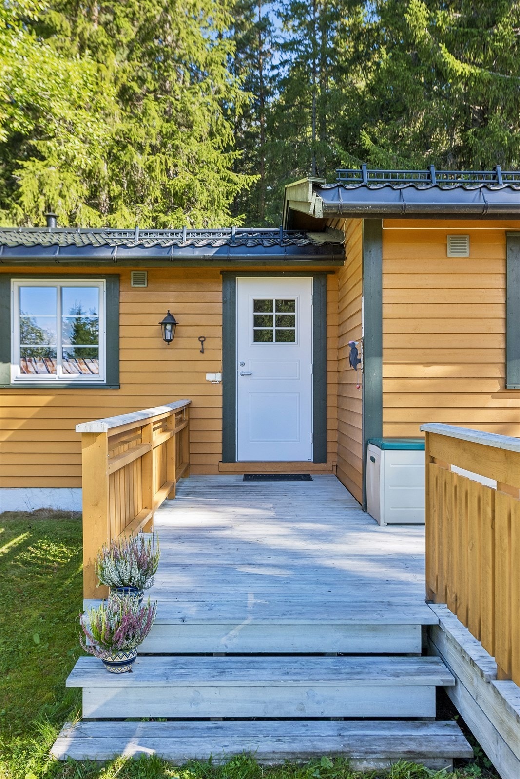 Overbygget inngangsparti med trapp og terrasseplatting som ønsker velkommen inn. Galleribilde