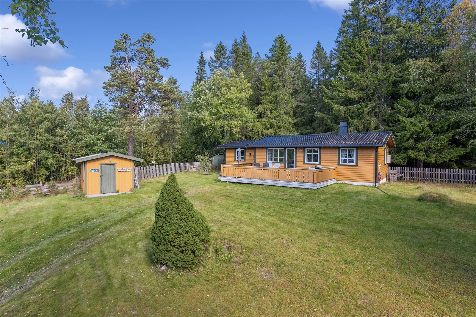 Hytta ligger lunt til på en åpen gressplen omkranset av høyreiste furutrær. Det er god plass til å parkerer på egen tomt og det er tilrettelagt for å sette inn elbillader om man har behov for dette. Galleribilde