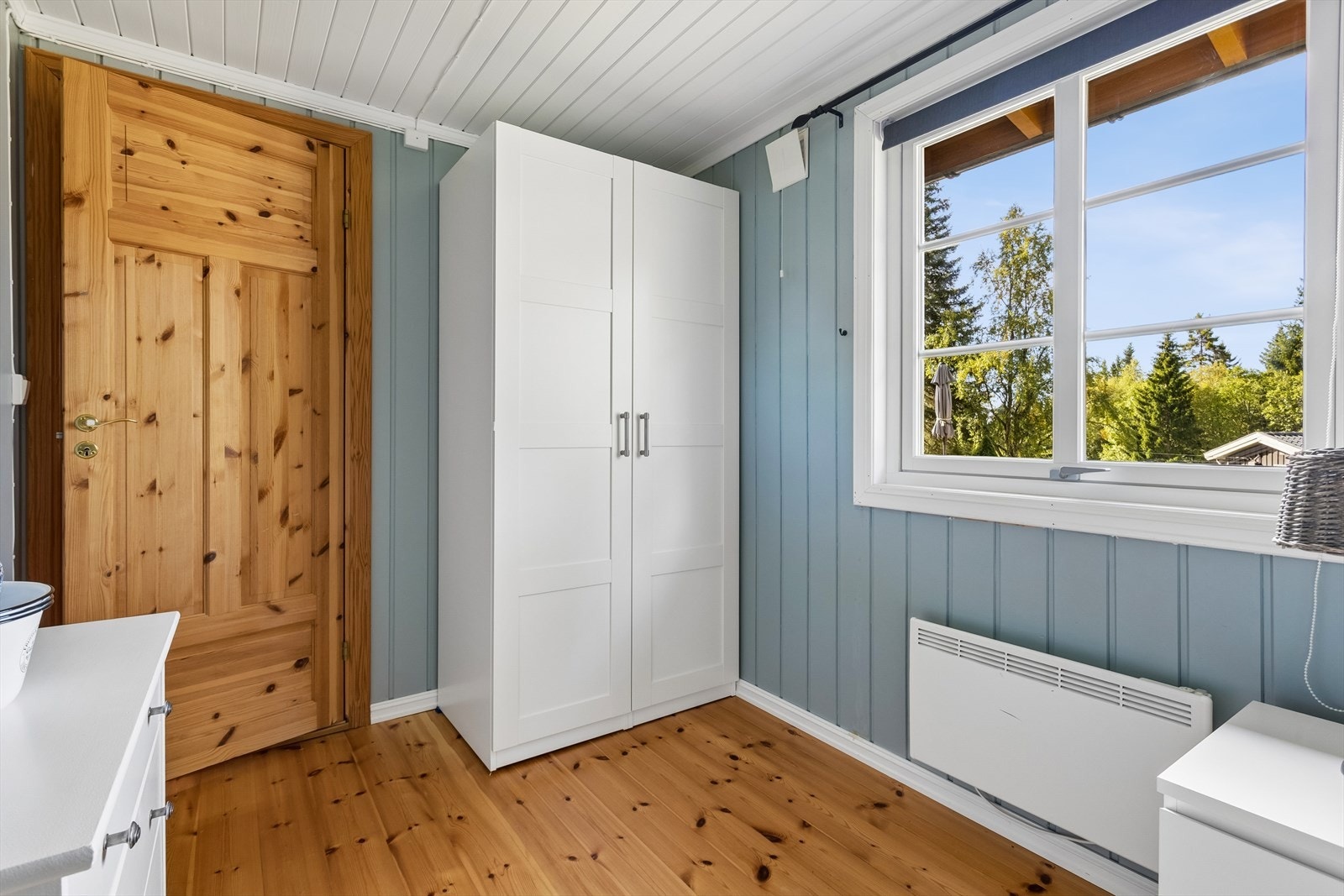 Hvitmalt himling og tregulv kompletterer rommet, som også har romslig garderobeskap. Galleribilde
