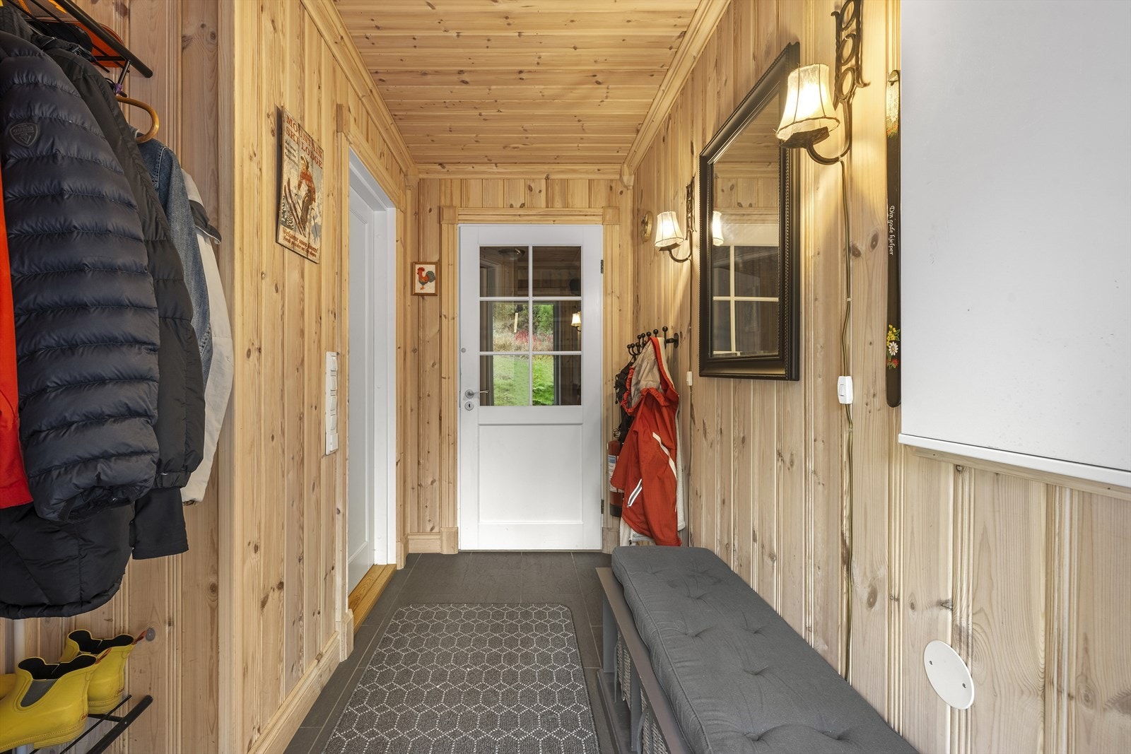 Fra overbygd inngangsparti, trer du inn i en lys entré med flislagt gulv med varmekabler. I entréen er det god plass til sko og yttertøy Galleribilde