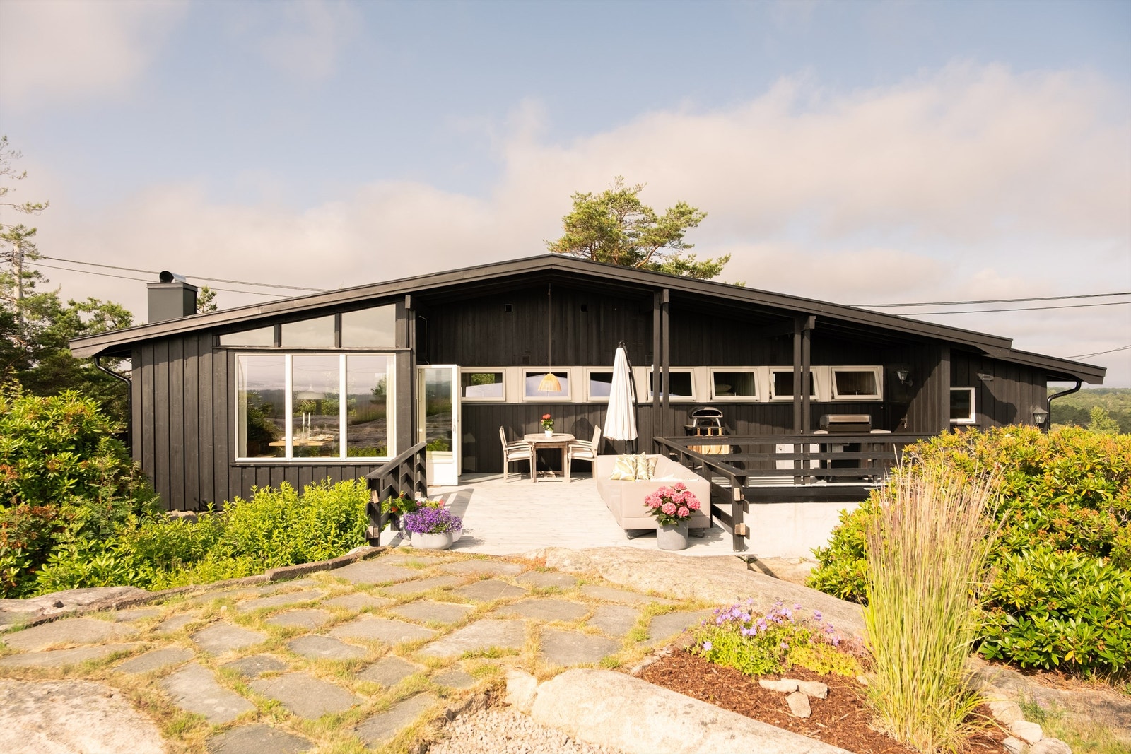 Hytta ligger flott til på en solrik naturtomt, hvor morgensolen treffer uteplassen og skaper en lun og innbydende atmosfære fra tidlig på dagen. Galleribilde