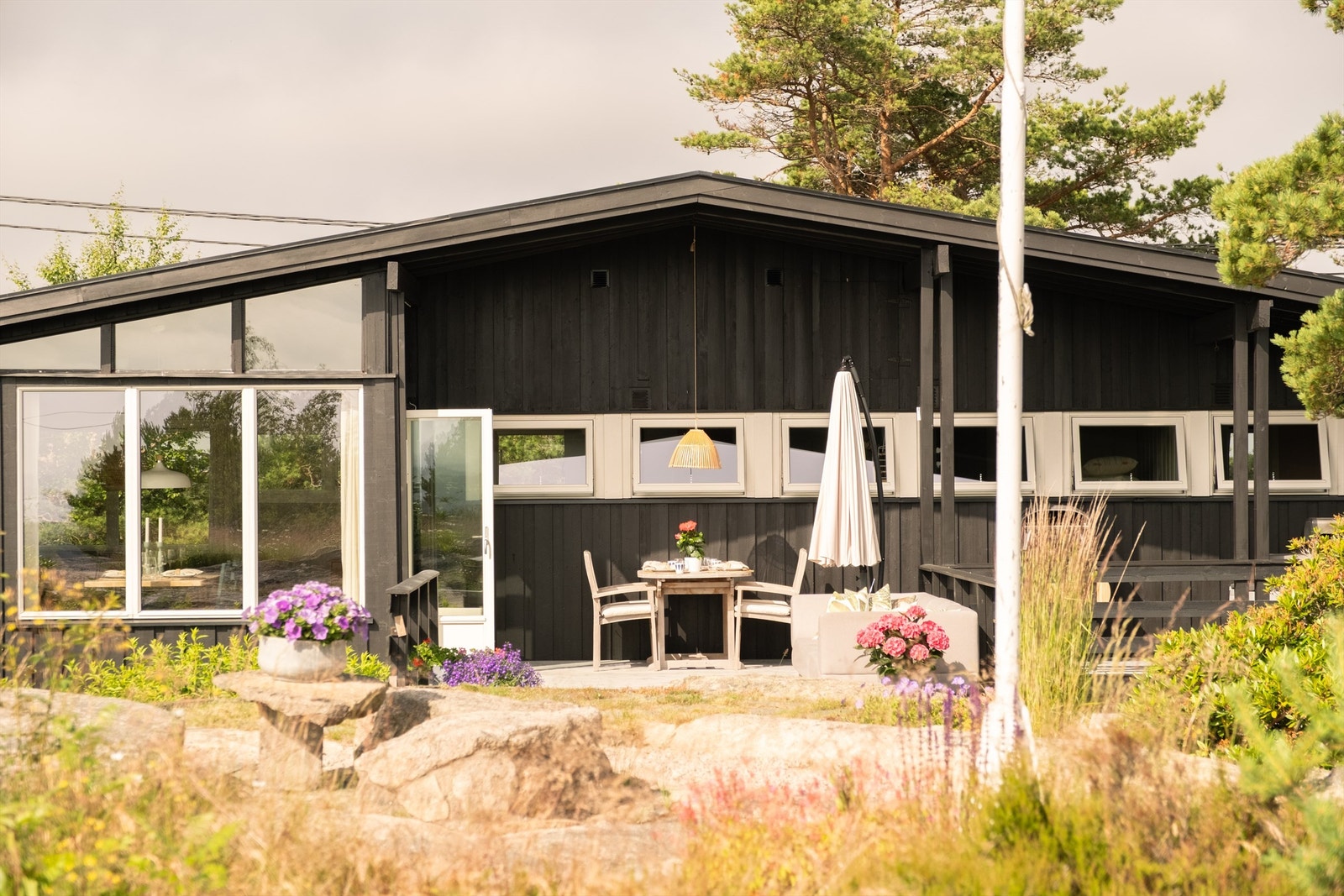 Et innbydende uteområde med gode soner for både avslapning og hyggelige måltider utendørs - perfekt plassert for å nyte den deilige morgensolen på Hvaler. Galleribilde