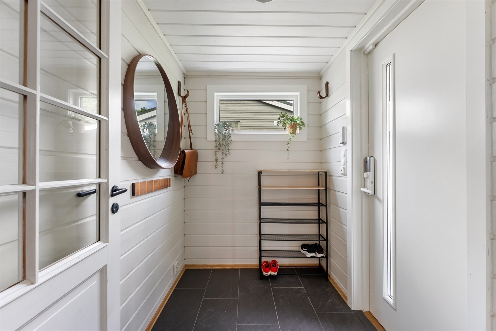 Entré med flislagt gulv og plass til yttertøy og sko. Galleribilde
