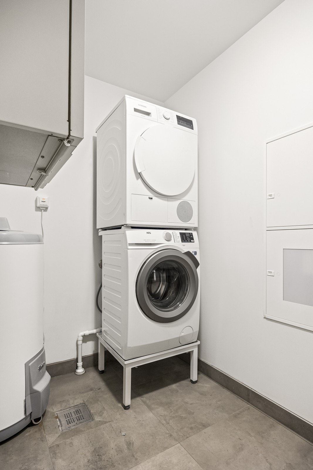 Praktisk vaskerom med flislagt gulv, sluk og opplegg for vaskemaskin/tørketrommel. Galleribilde