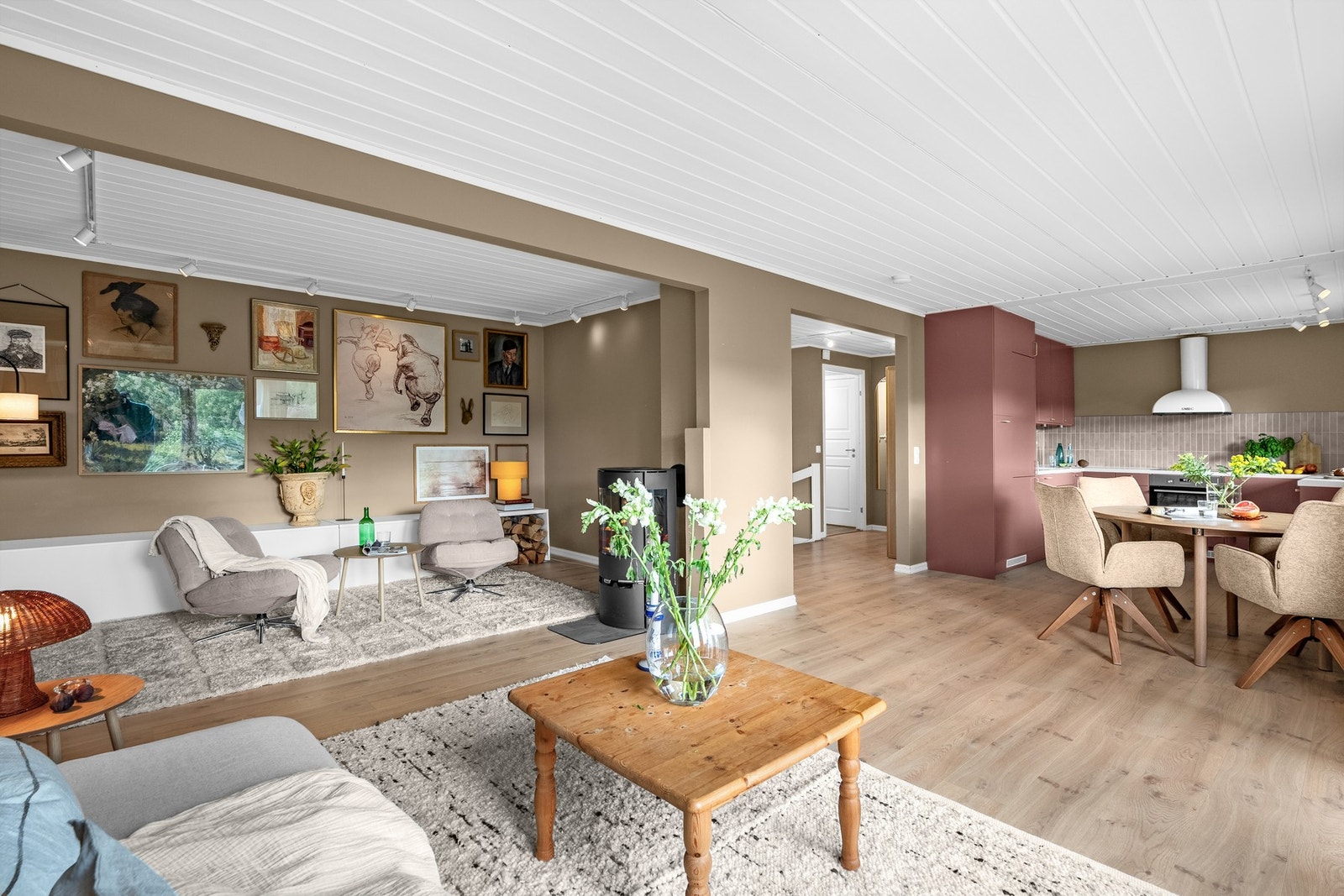 Rommet er delt i to soner, med åpen løsning til kjøkkenet og god plass til både tv-lounge, spisestue og annet møblement. Galleribilde