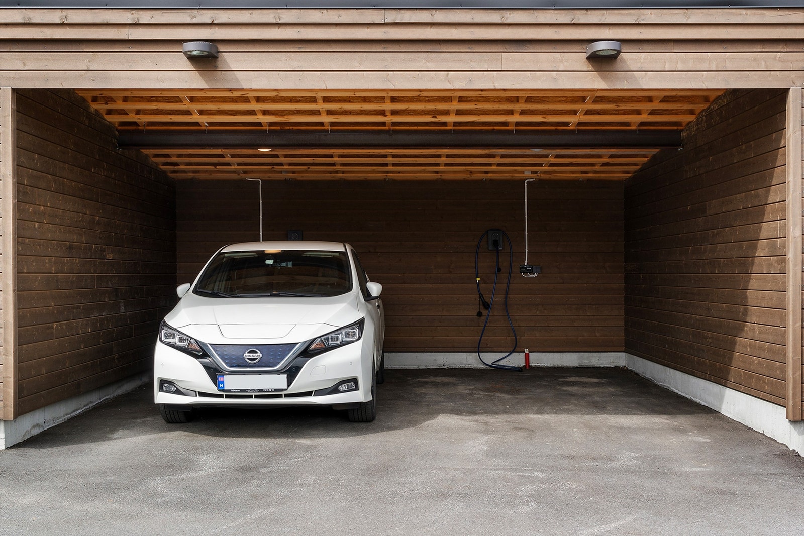Plassen lengst til høyre i carport tilhører boligen. Legg merke til at det allerede er installert elbil-lader Galleribilde