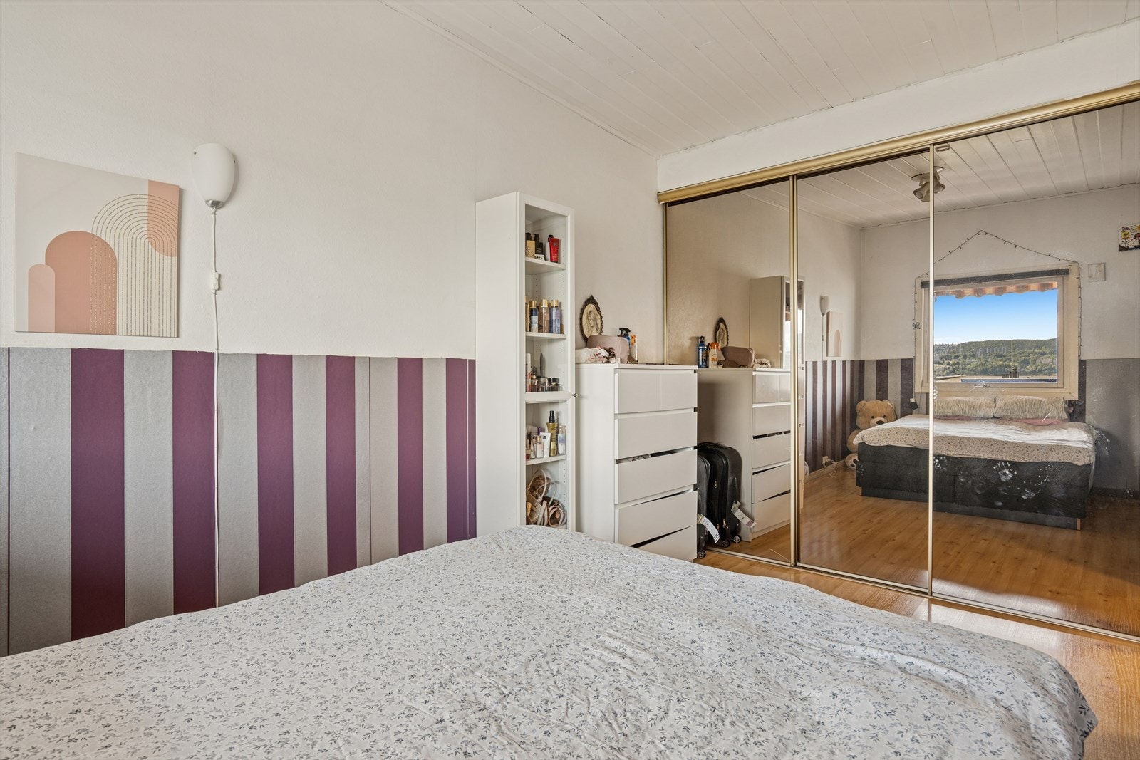 Soverommet er innredet med en romslig skyvedørsgarderobe med speilfronter. Galleribilde