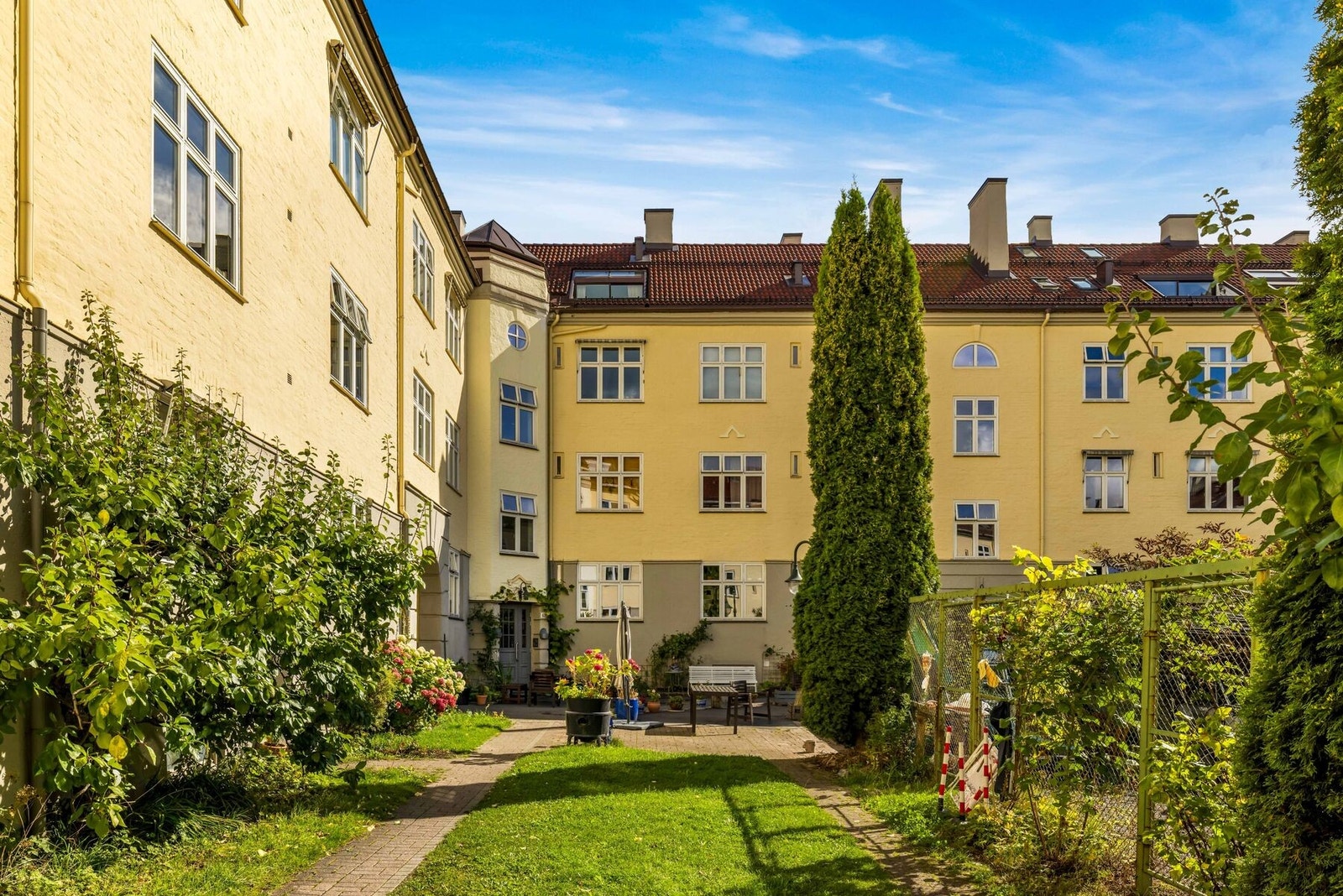Det parkmessige gårdsrommet legger til rette for et godt "uteliv" i den varme årstiden. Galleribilde
