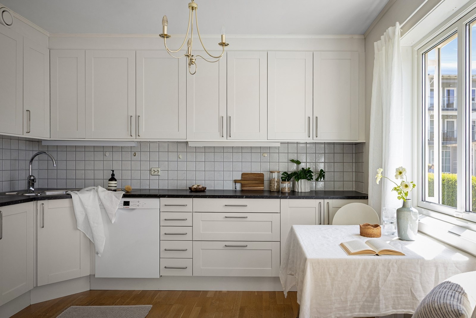 Kjøkkenet er som resten av boligen i nøytrale tone og oppleves tidløst og funksjonelt. Det er plass til større spisebord i stuen, men dette kjøkkenbordet gir et godt, praktisk element til hverdagen. Galleribilde