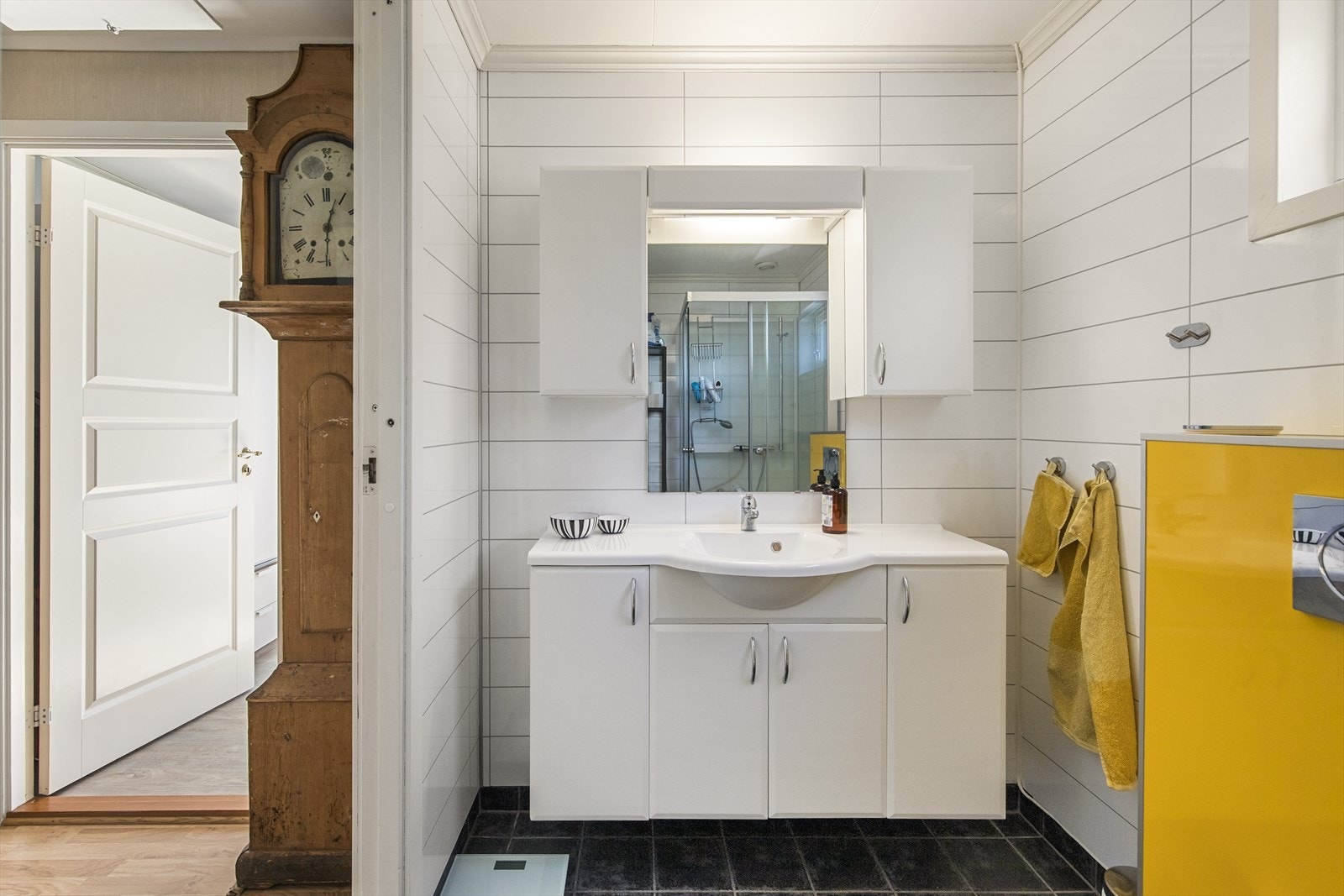 Hovedbadet i denne etasjen er flislagt på gulv og vegger, og er innredet med vegghengt dusjtoalett, stort baderomsmøbel med formstøpt servant, speil, veggskap og et romslig dusjkabinett. Galleribilde