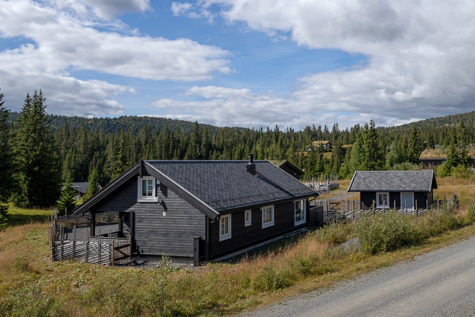 Hytta har en gjennomgående stil med liggende utvendig trekledning og tak tekket med asfaltshingel. Galleribilde