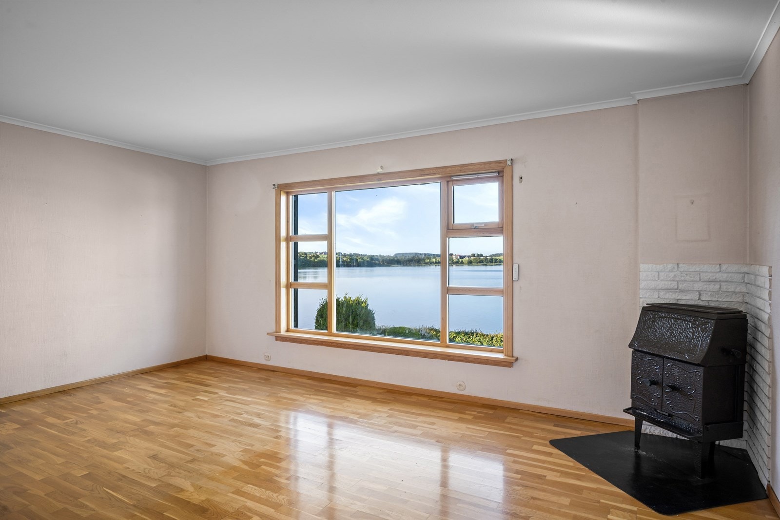 Stuen har parkett på gulvet og en eldre vedovn tilknyttet mursteinspipe. Galleribilde