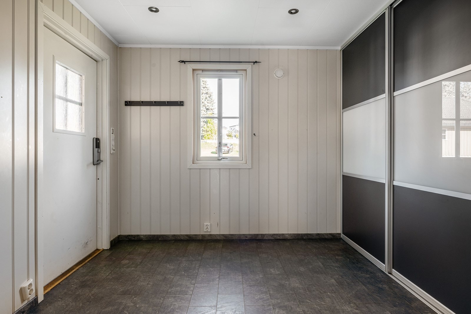 Romslig entré med skyvedørsgarderobe. Galleribilde