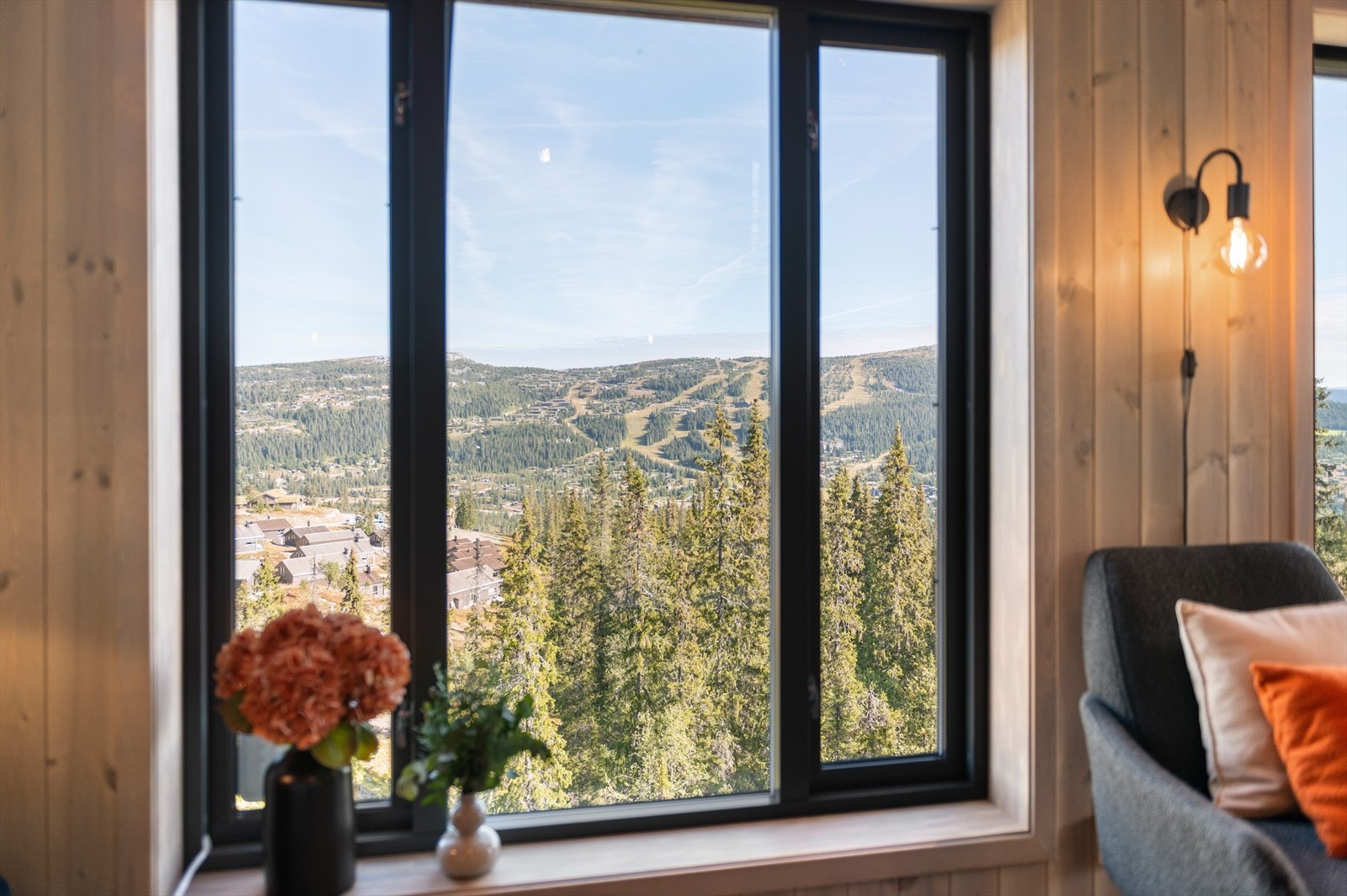 Utsyn mot fjellheimen og skogkledde åser fra oppholdsrommet. Galleribilde