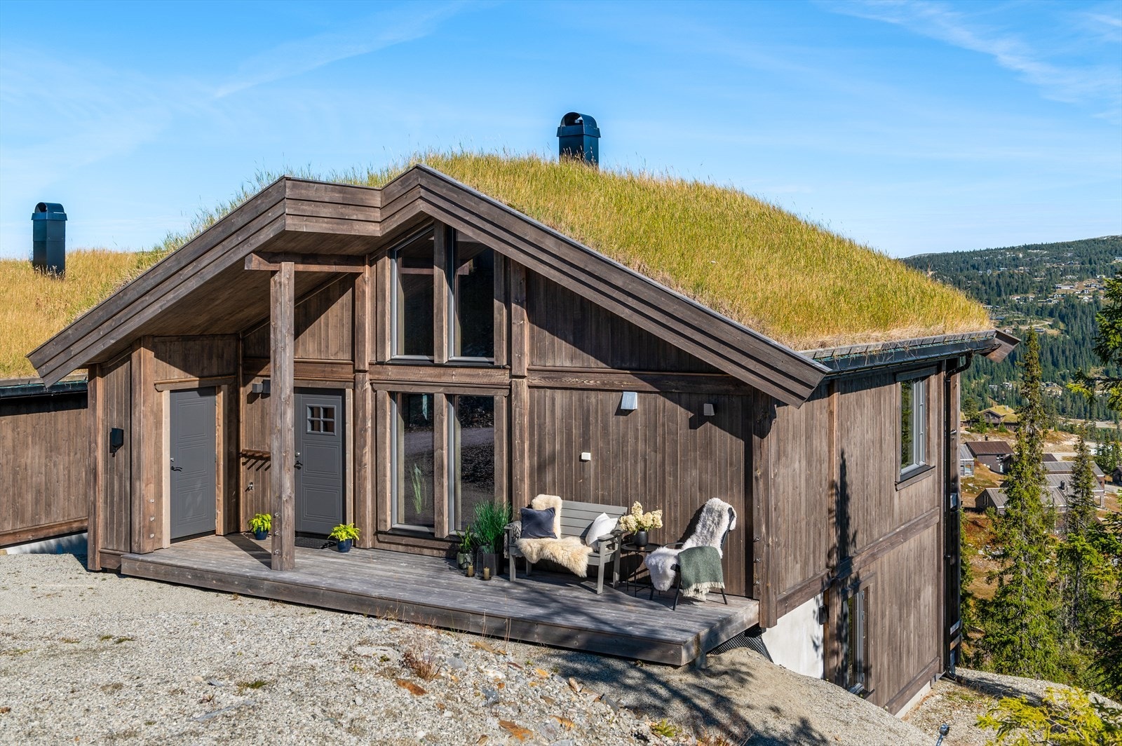 Eiendommen har to oppstillingsplasser og elbillader montert på hytteveggen. Galleribilde