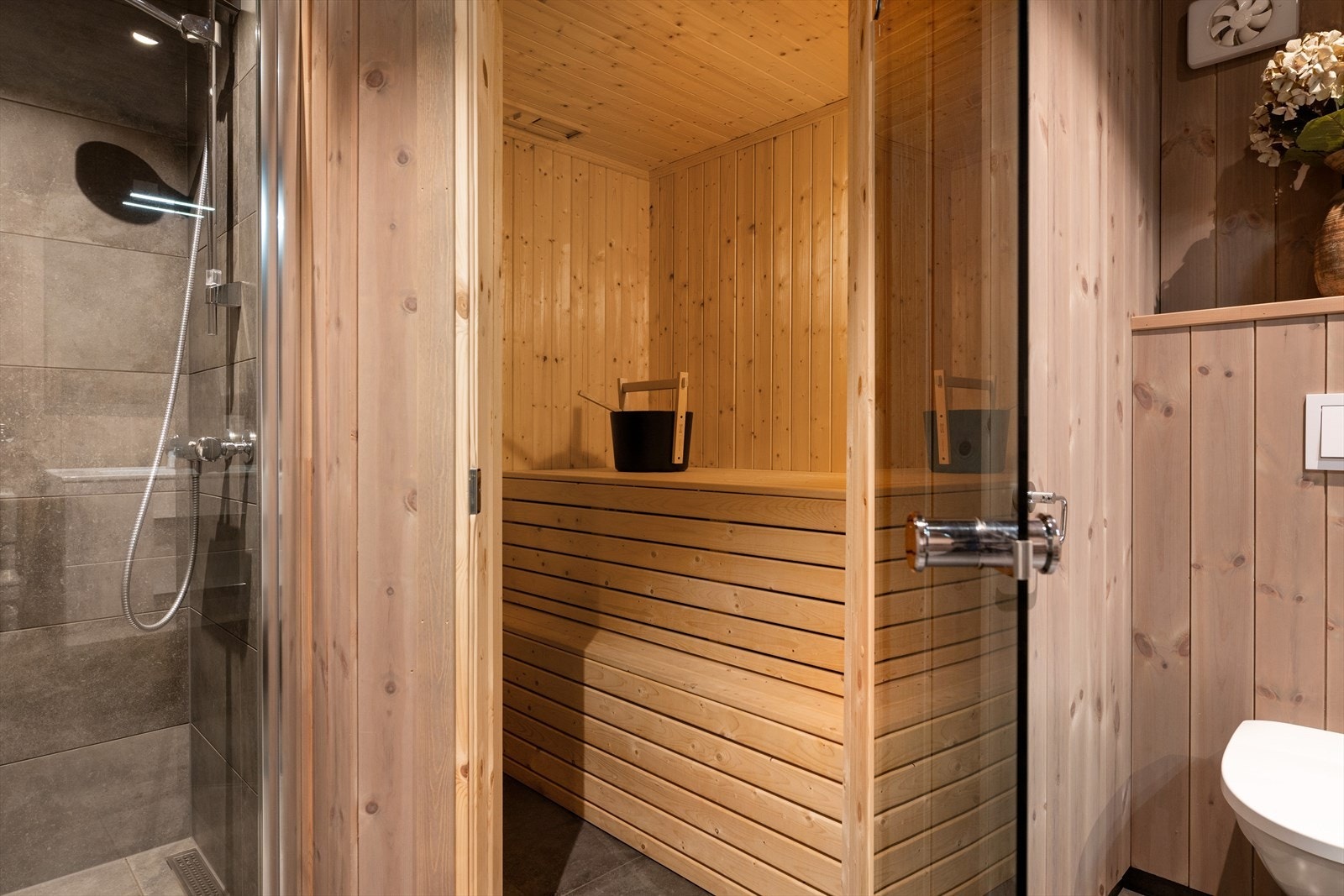 Badstuedør i sotet, herdet glass leder inn til den plassbygde badstuen. Galleribilde