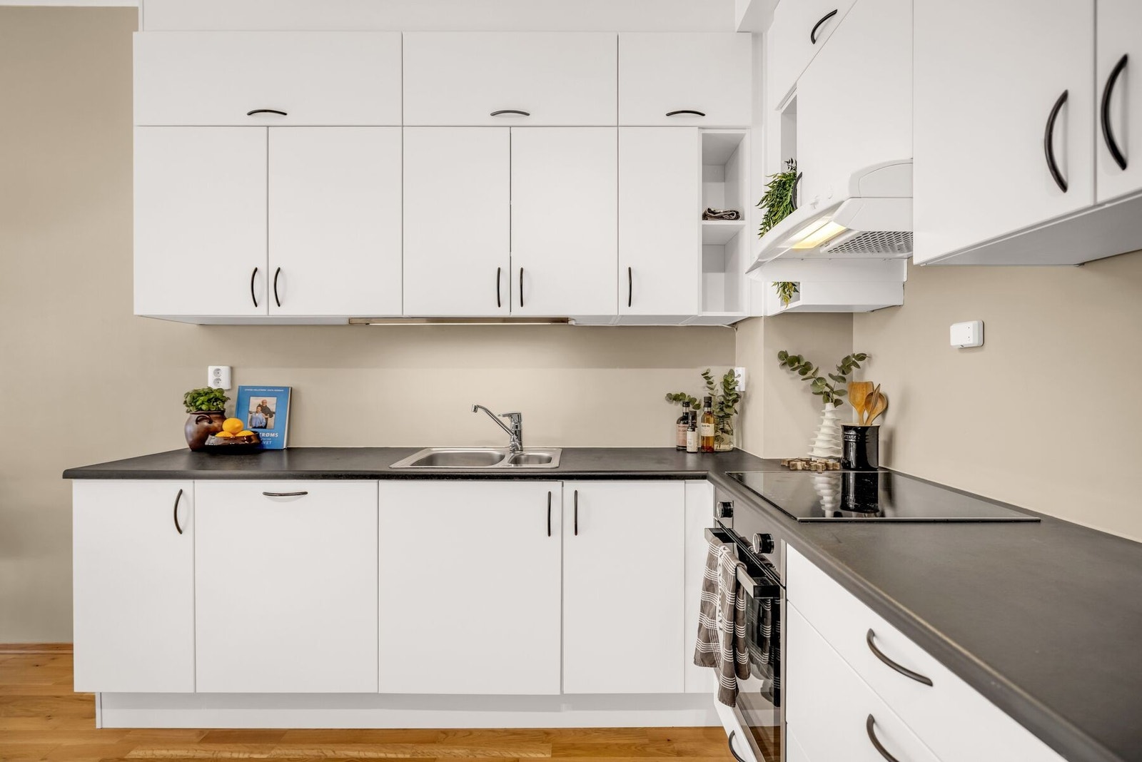 Kjøkkeninnredningen har et stilrent uttrykk med glatte fronter og laminat benkeplate med nedfelt kum i rustfritt stål. Galleribilde