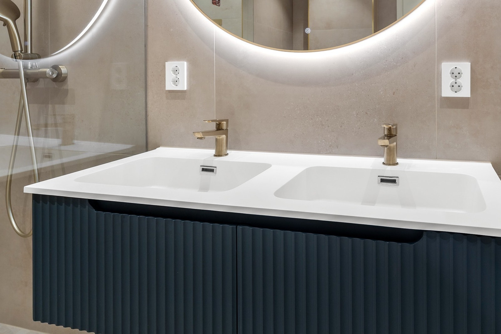 Badet er utstyrt med innredning med to nedfelte servanter, vegghengt toalett og dusjhjørne med dusjvegger Galleribilde