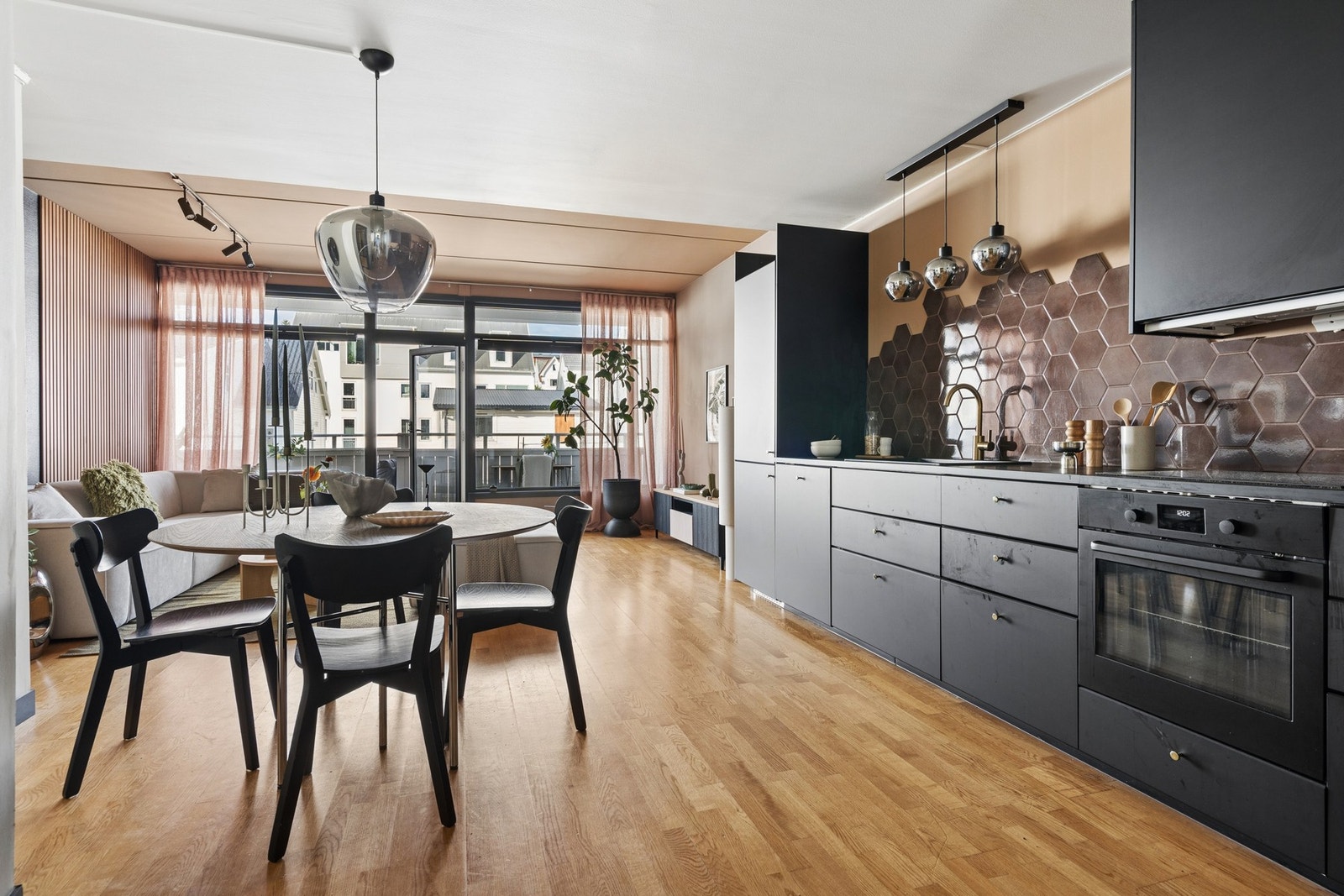 Kjøkkeninnredning med glatte, mørke fronter og laminatbenkeplate. Galleribilde