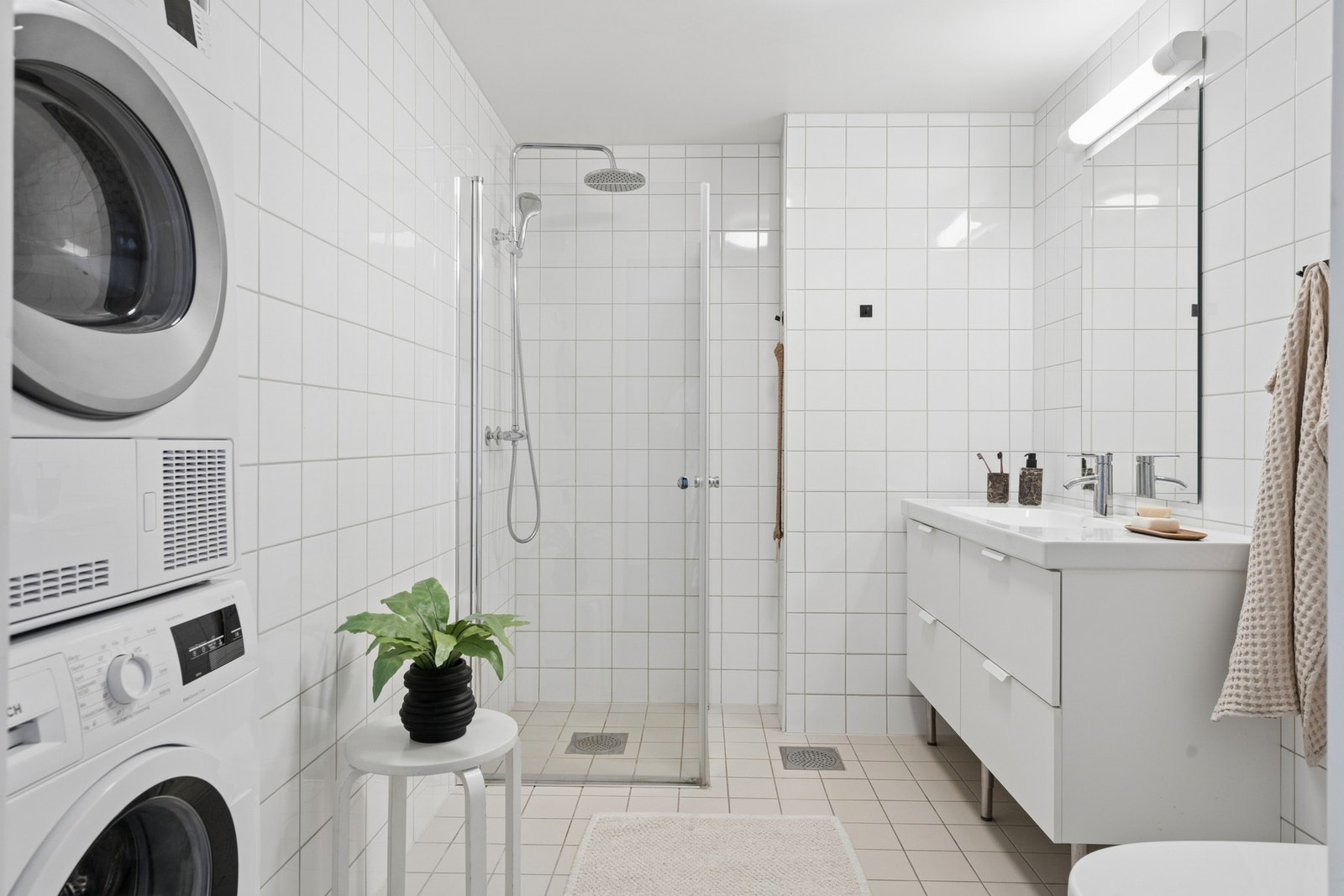 Badet har dusjhjørne med innfellbare glassdører og opplegg for vaskemaskin. Galleribilde