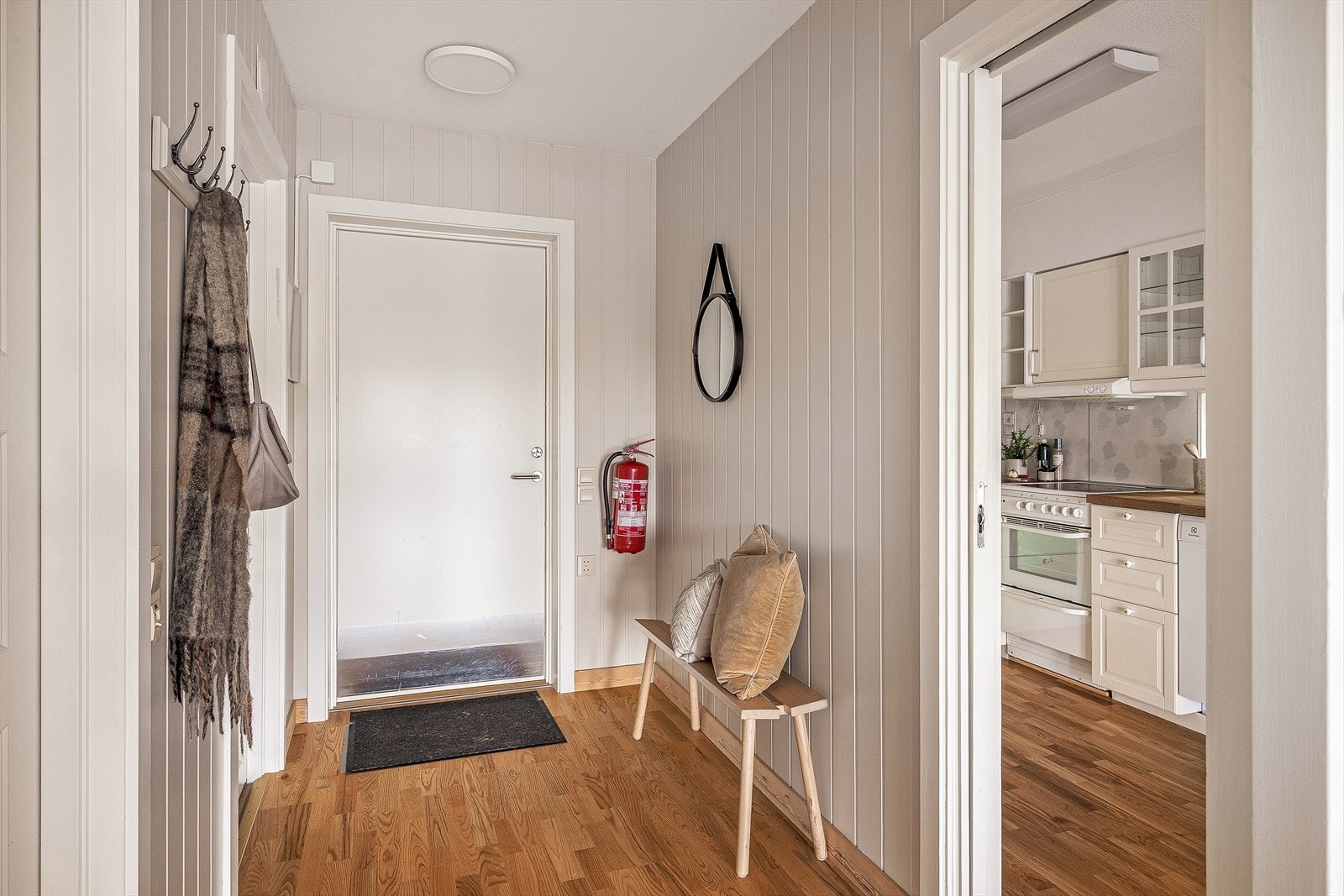 Lys entré med mdf-panel på veggene og parkett på gulvet. Galleribilde