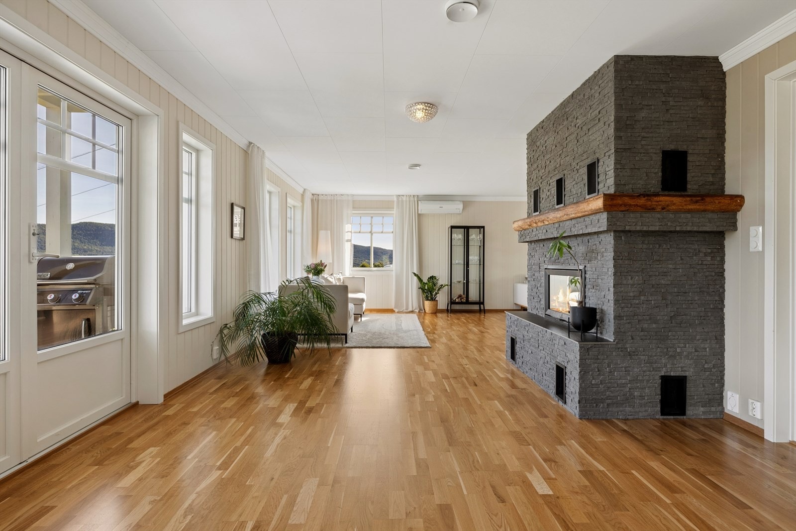 Hovedetasjen har en åpen og romslig løsning med peisen sentralt plassert. Galleribilde