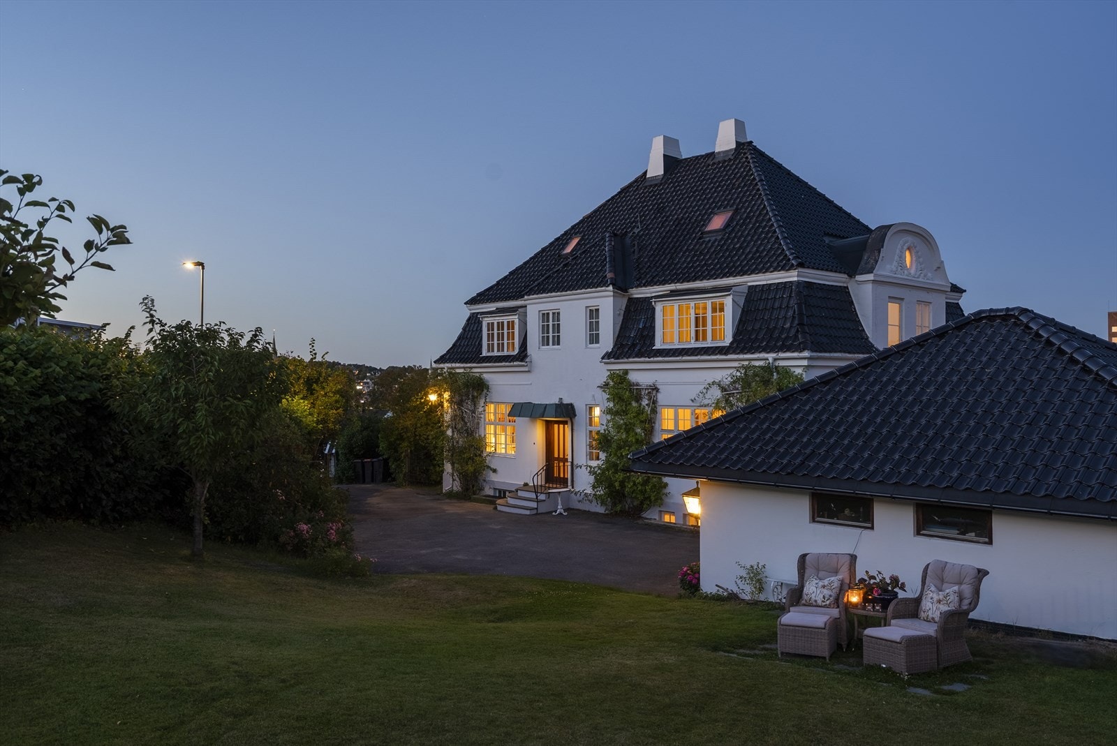 Stemningsfullt kveldsbilde av den herskapelige villaen, hvor klassisk arkitektur og vakker belysning skaper en helt spesiell atmosfære Galleribilde