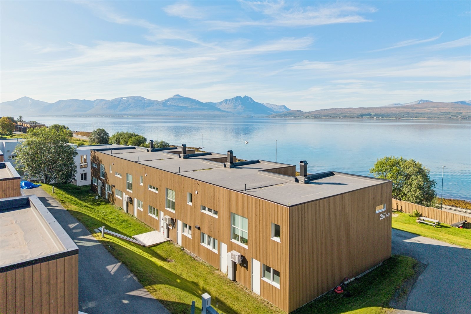 Her bor du i naturskjønne omgivelser langs kystlinjen, med sjøen like nedenfor og flott utsikt mot sundet og fjellene på den andre siden. Boligfeltet har fine fellesarealer med opparbeidet lekeplass like ved rekkehuset. Galleribilde