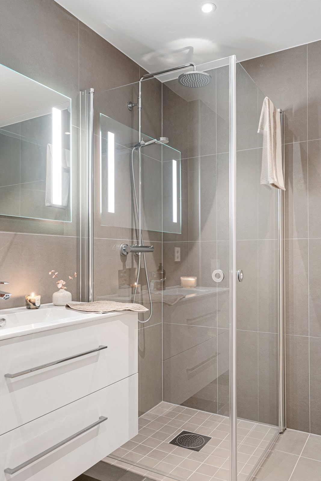 Badet inneholder innredning med servant, dusjnisje, vegghengt toalett og opplegg for vaskemaskin bak skyvedør Galleribilde