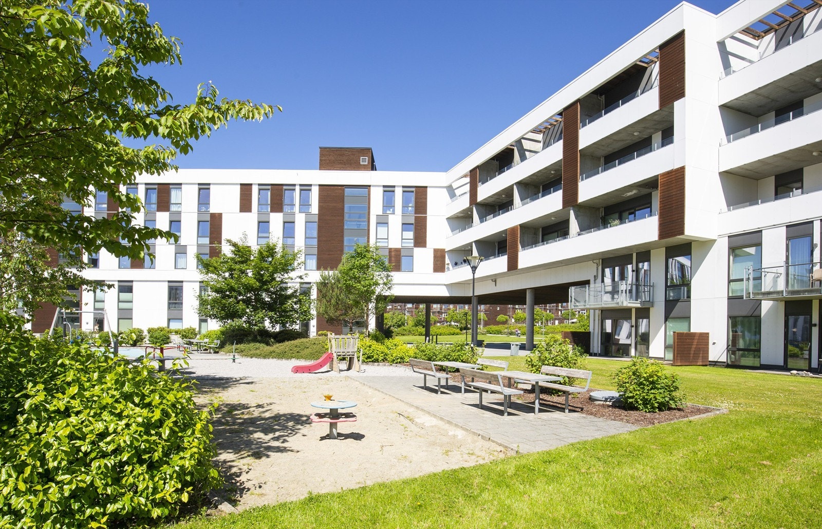 Borettslagets felles tomt er opparbeidet med plen, sittebenker og lekeareal. Galleribilde