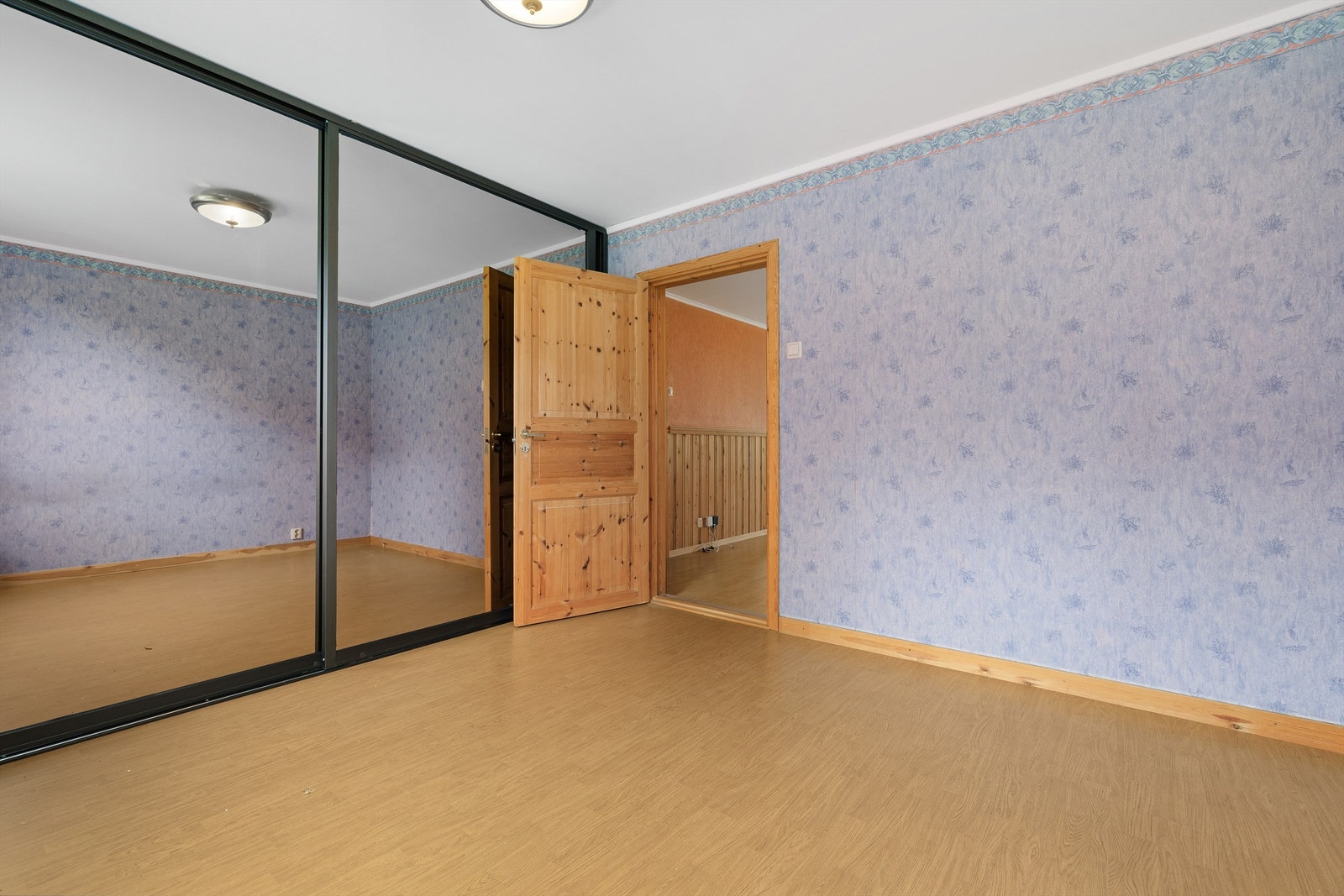 En stor skyvedørsgarderobe med speilfronter gir rikelig med oppbevaringsplass. Galleribilde