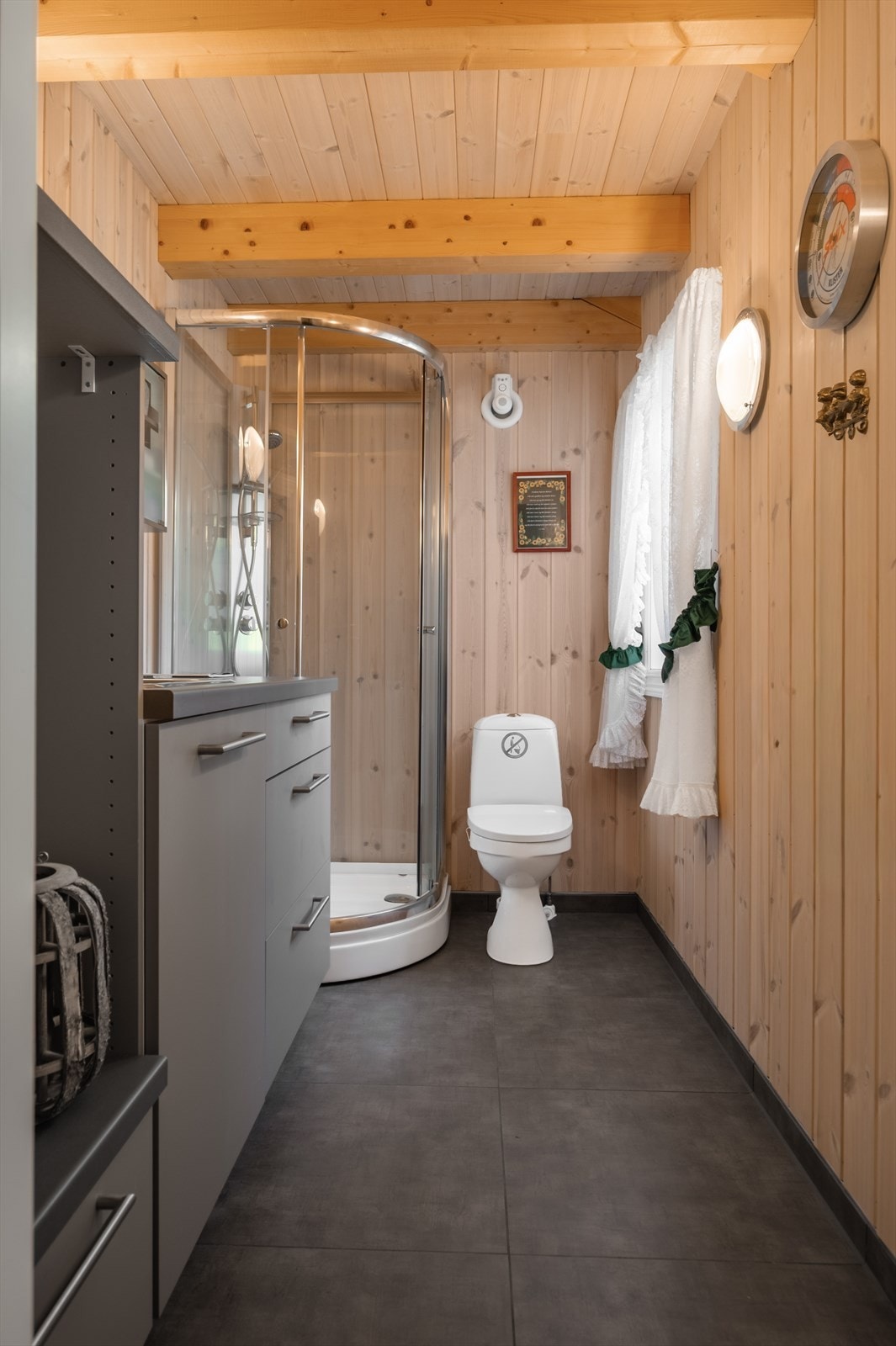 Rommet er utstyrt med moderne innredning med opplegg for vaskemaskin og nedfelt vaskekum, dusjkabinett og gulvstående toalett. Galleribilde