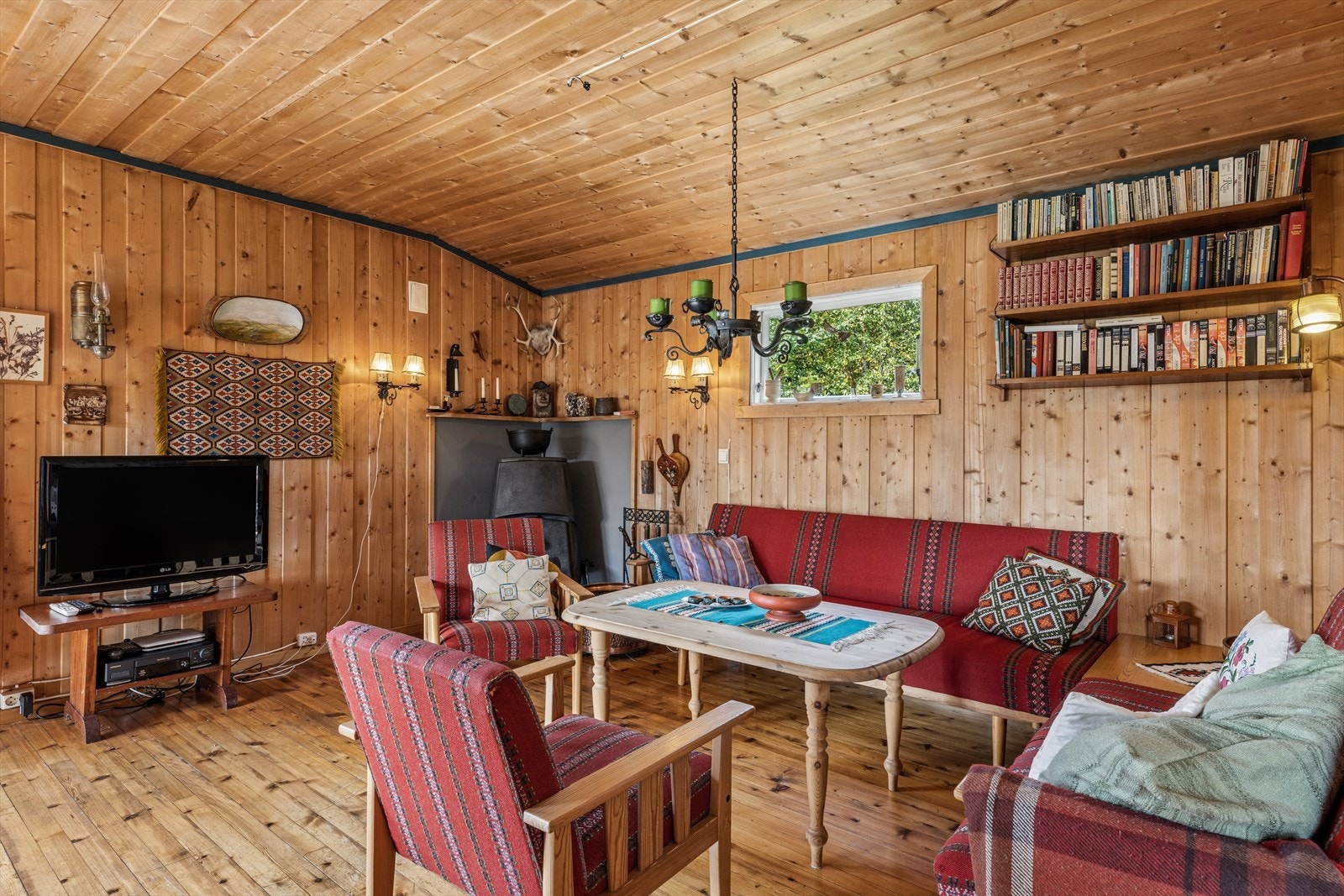 Tregulv og panelkledde flater gir et helhetlig, klassisk hyttepreg. Galleribilde