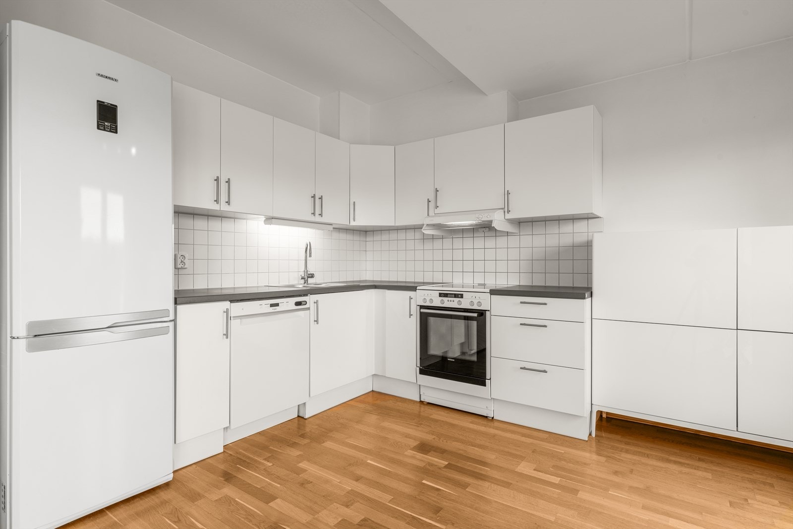 Kjøkkeninnredningen er fra byggeår og har et tidløst uttrykk med hvite, slette fronter og laminat benkeplate. Det er opplegg for oppvaskmaskin, komfyrvakt og avtrekk via boligens mekaniske avtrekksanlegg. Galleribilde