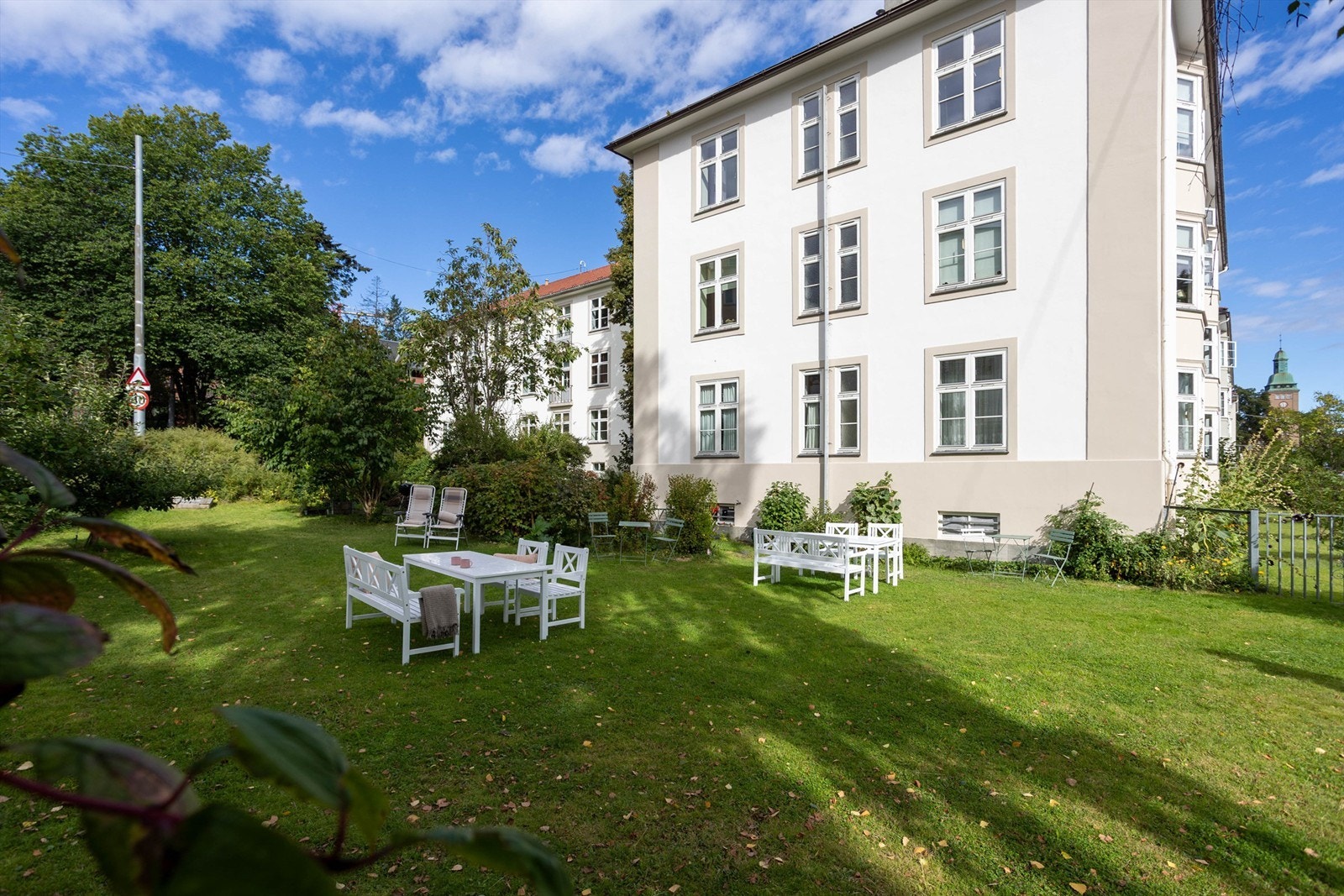 En idyllisk felles hage med grønne plener, sittegrupper og god plass til å nyte sommerdagene. Galleribilde