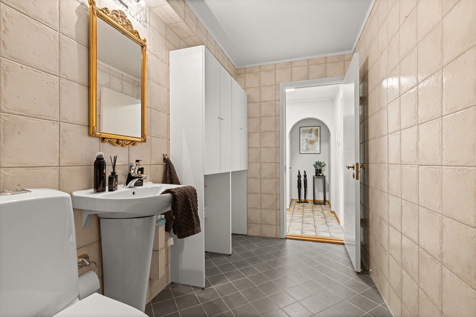 Badet er utstyrt med dusjløsning, servantinnredning og opplegg for vaskemaskin Galleribilde
