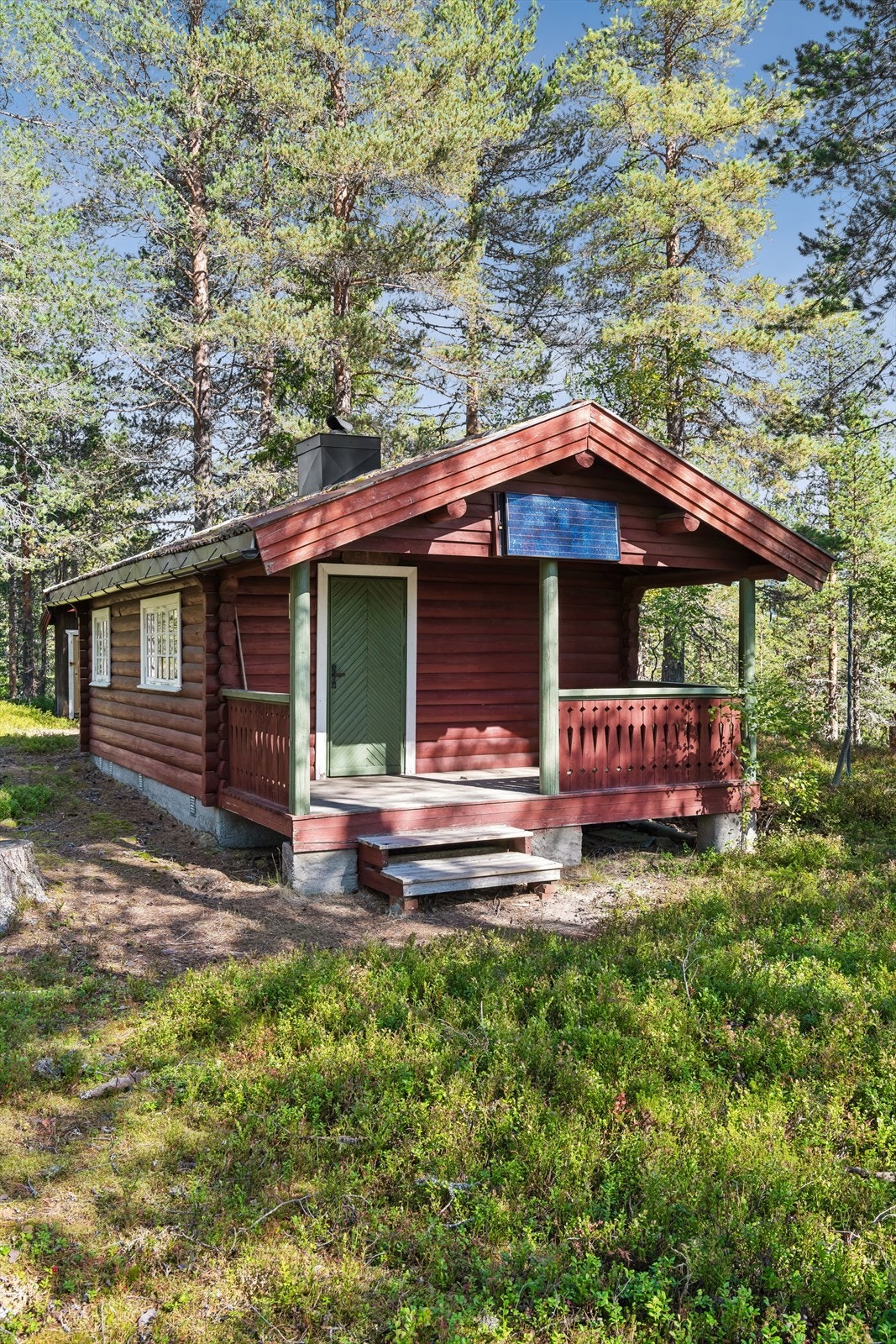 Yttervegger i maskinlaftet tømmer og tak tekket med klassisk tegltakstein. Galleribilde