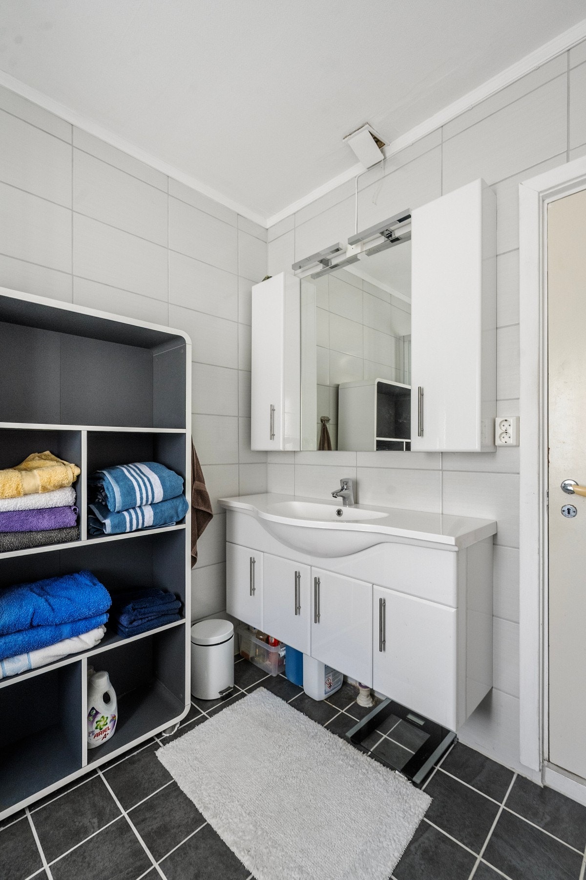 Badet er opplyst å være fra ca. 2016. Rommet har flislagte gulv og vegger, servant med underskap, dusjkabinett og opplegg for vaskemaskin. Det er varmekabler i gulvet og ventilasjon via ventil i vegg. Galleribilde