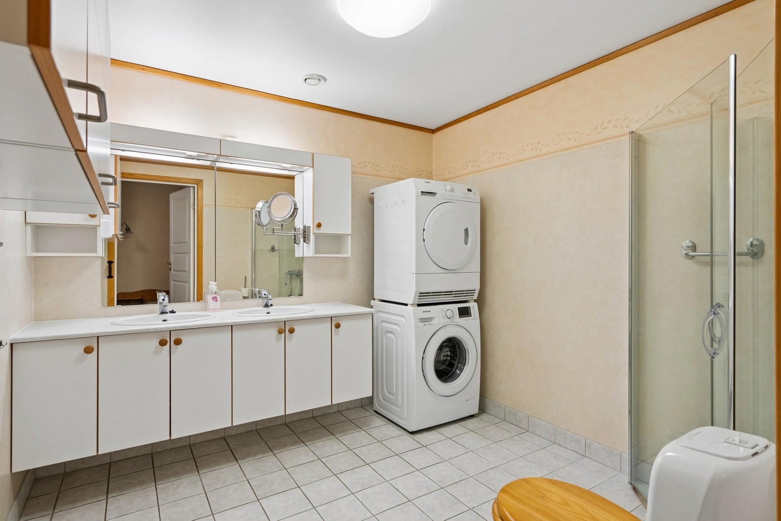 Kombinert bad og vaskerom med flislagt gulv, varmekabler og opplegg for vaskemaskin. Galleribilde