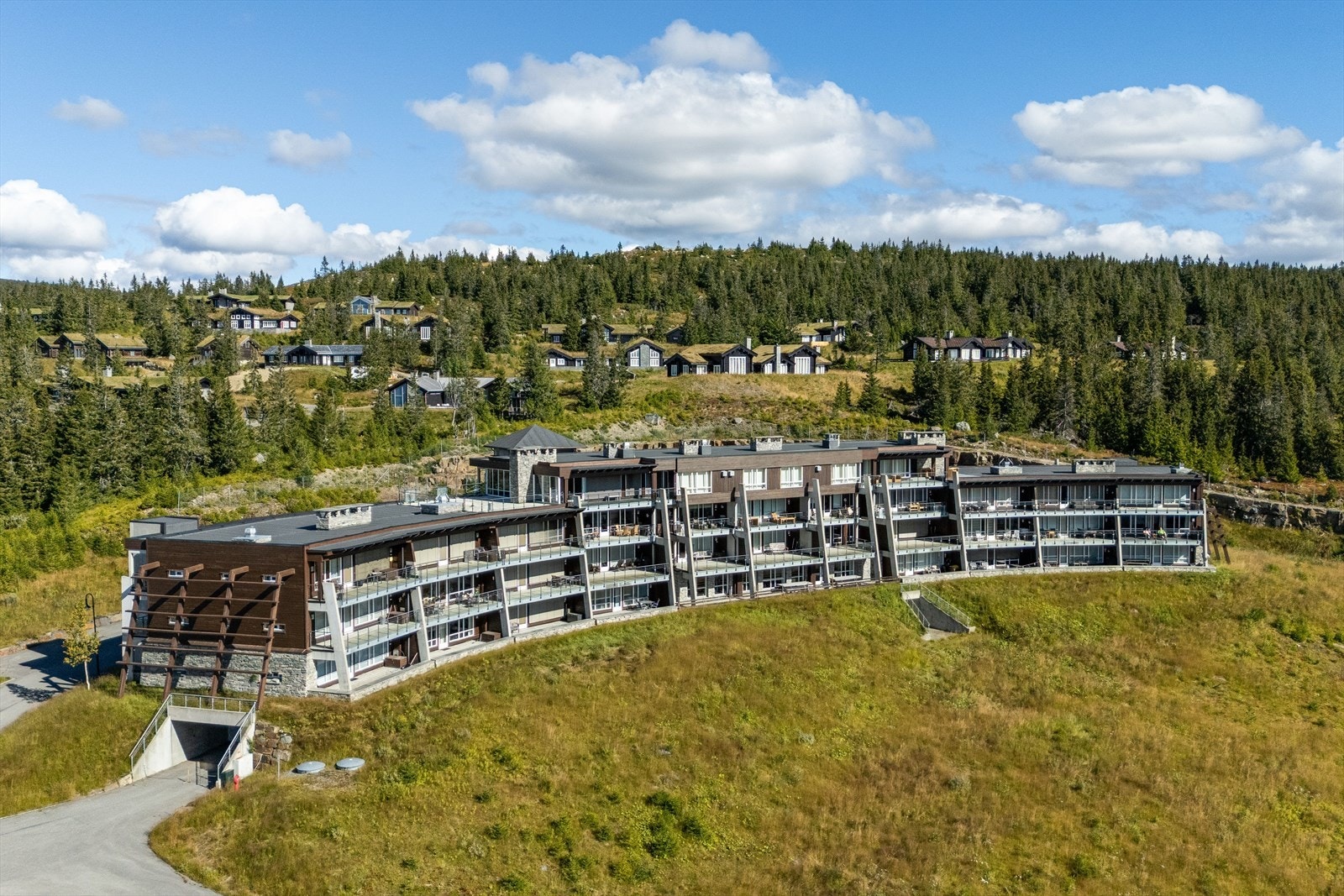 Leilighetsbygget fra 2005 har en karakteristisk buet form tilpasset terrenget. Galleribilde
