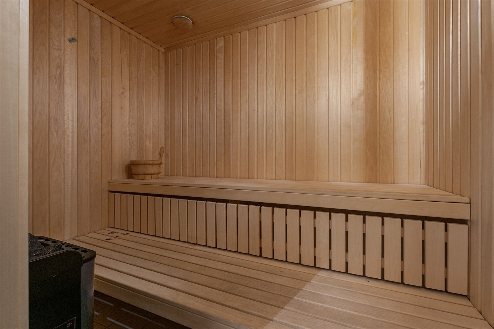 Tradisjonell badstue kledd i trepanel, utstyrt med sittebenker og badstueovn. Galleribilde