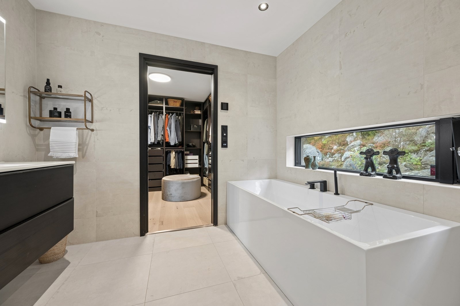 Badet er innredet med store, grå fliser på gulv og vegger. I gulvet har man også varmekabler for ekstra komfort. Galleribilde