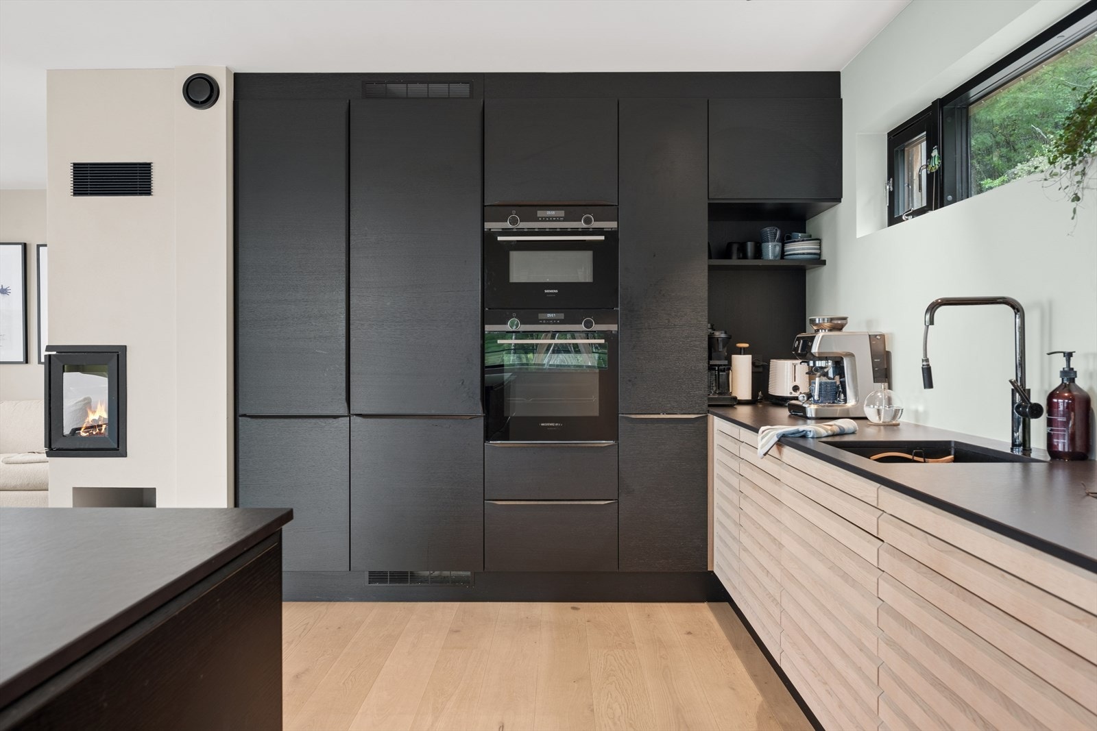 Detaljer som sokkelskuffer, egen nisje til kaffemaskin og sitteplasser ved kjøkkenøyen gir det lille ekstra. Galleribilde